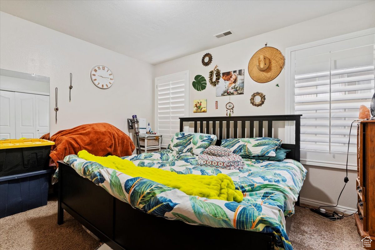 Bedroom featuring carpet and a closet