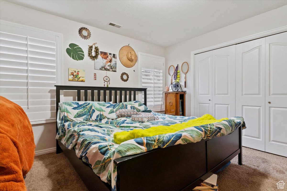 Carpeted bedroom with a closet