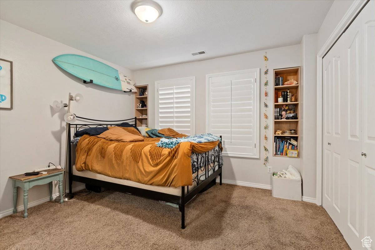 Bedroom featuring carpet and a closet