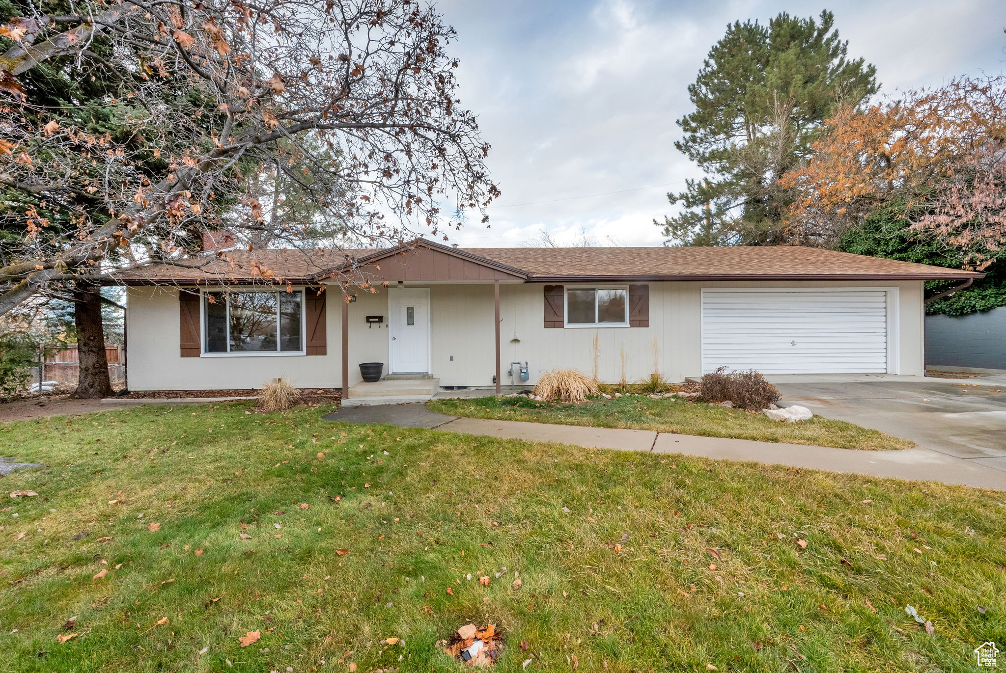 Ranch-style home with a garage and a front lawn