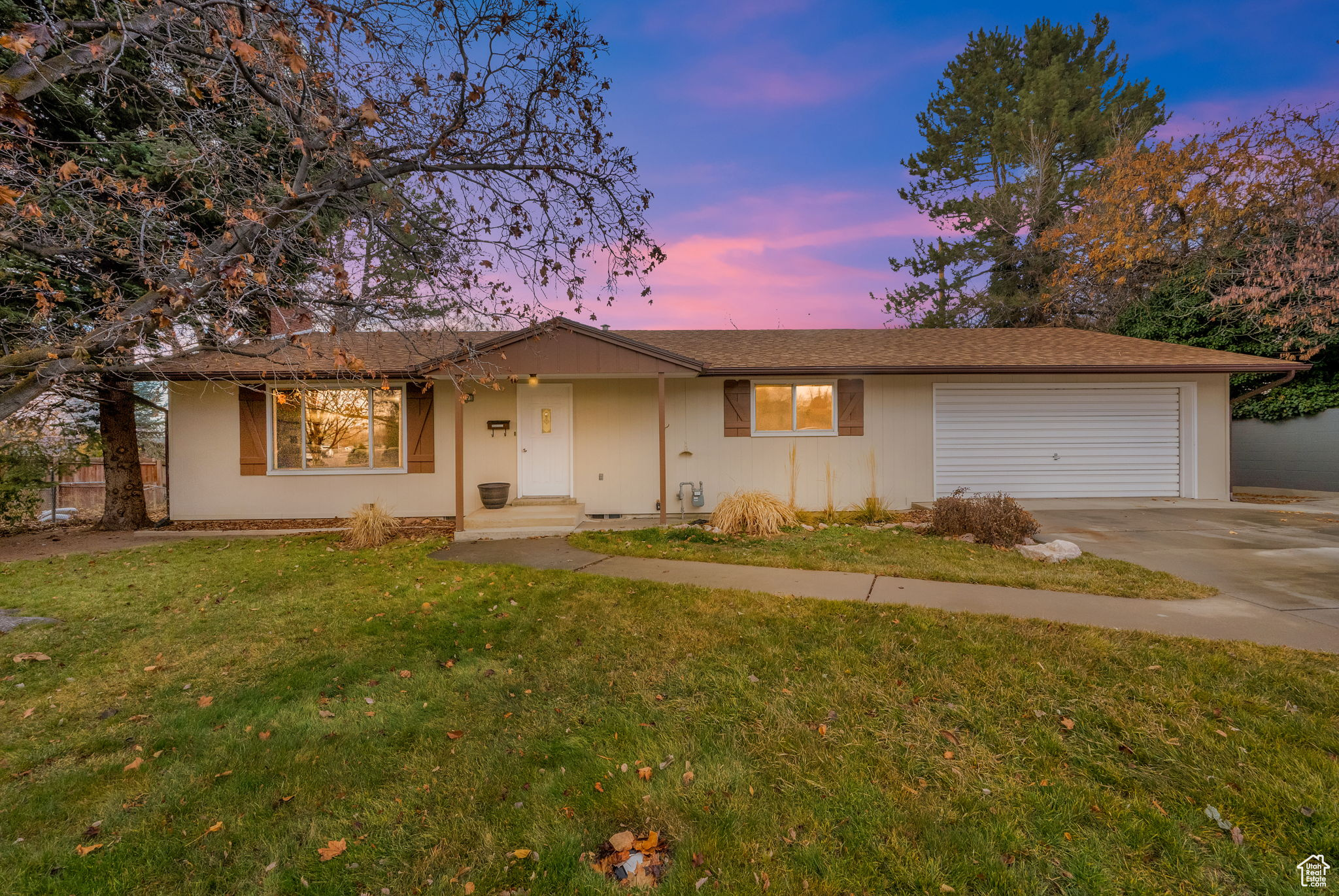 Ranch-style house featuring a garage and a yard