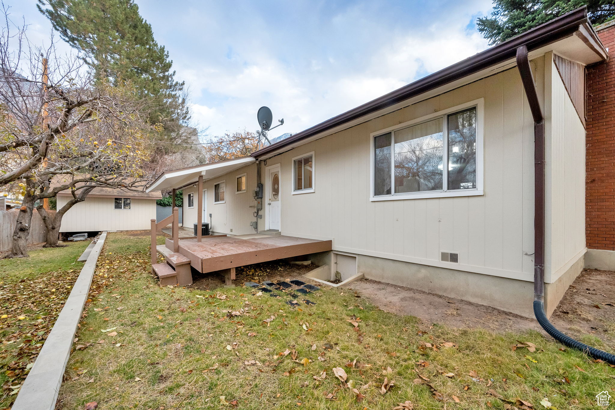 Rear view of property with a wooden deck and a lawn