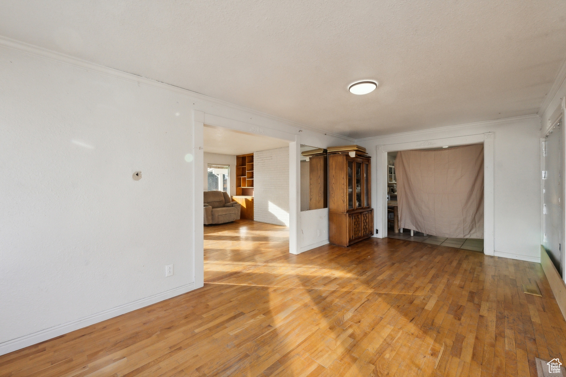 Empty room with wood-type flooring and ornamental molding