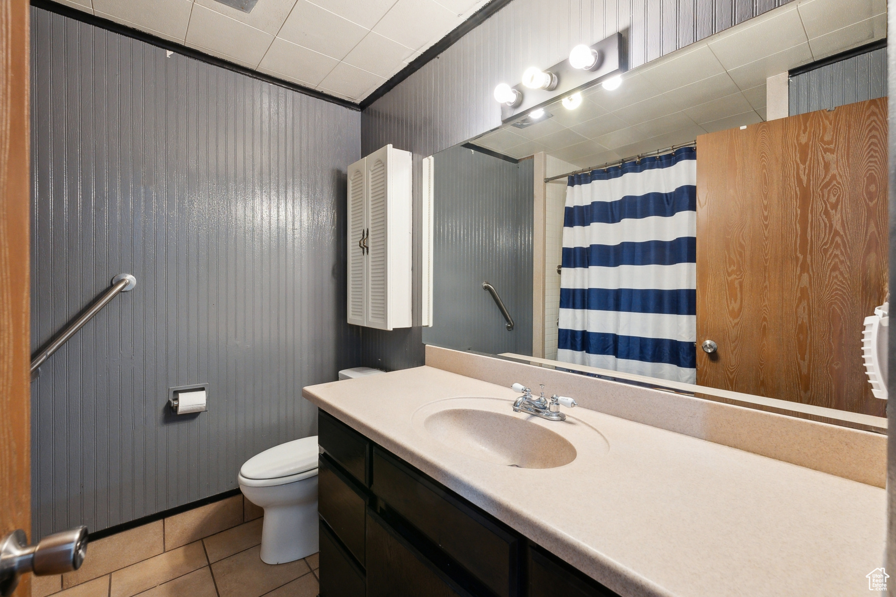 main full Bathroom with toilet, vanity, tile patterned floors, and walk in shower