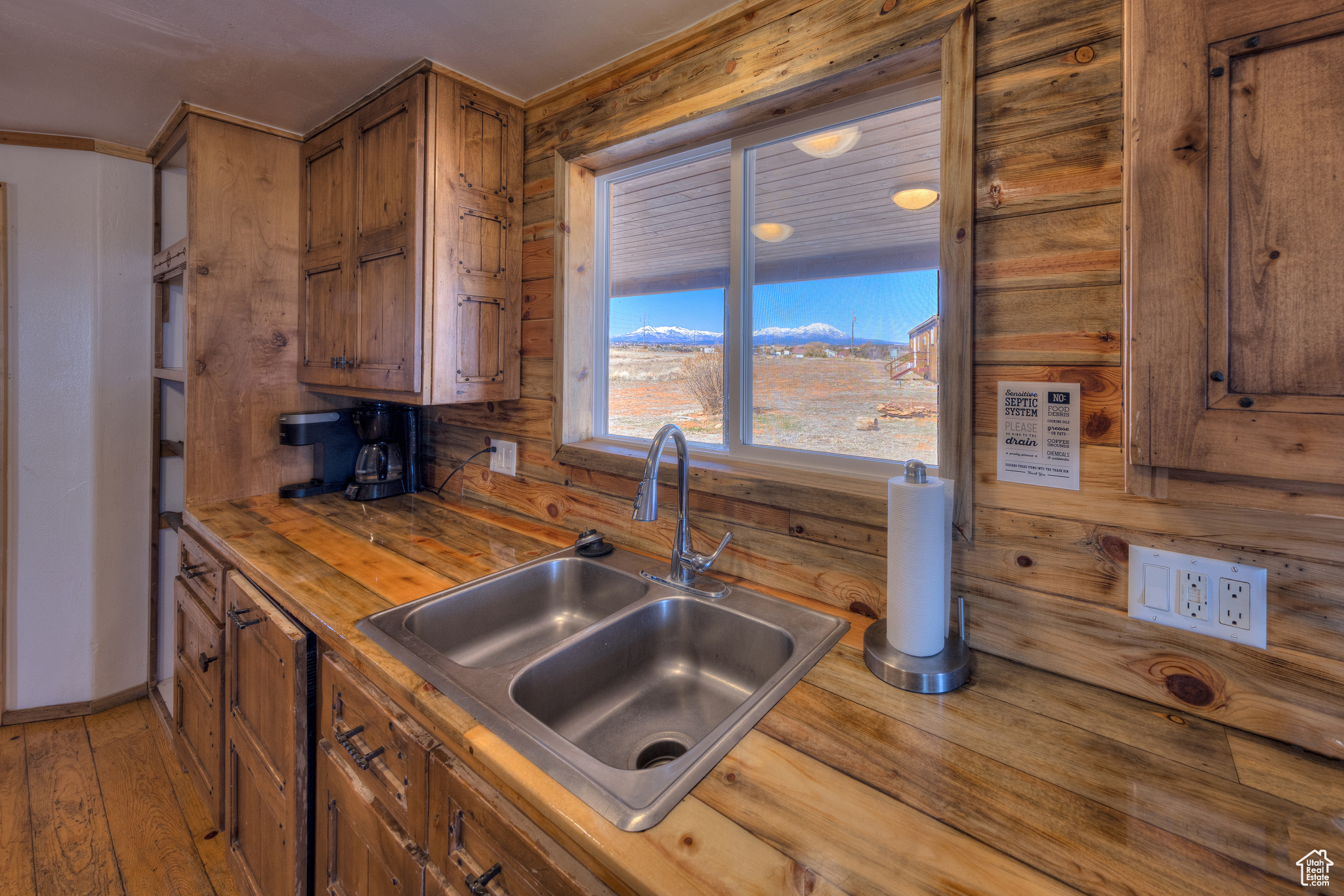 Kitchen featuring hardwood / wood-style floors, wood counters, wood walls, and sink