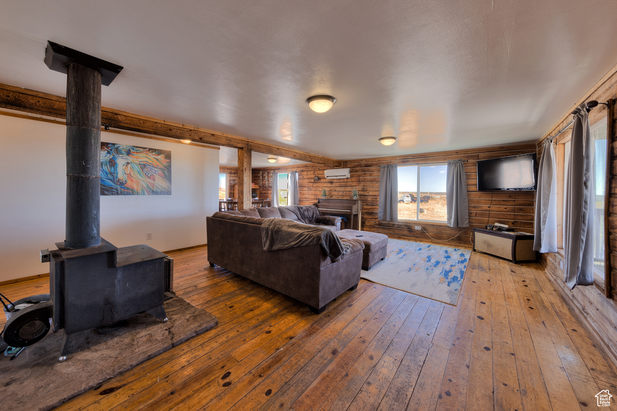 Living room featuring wood-type flooring and an AC wall unit