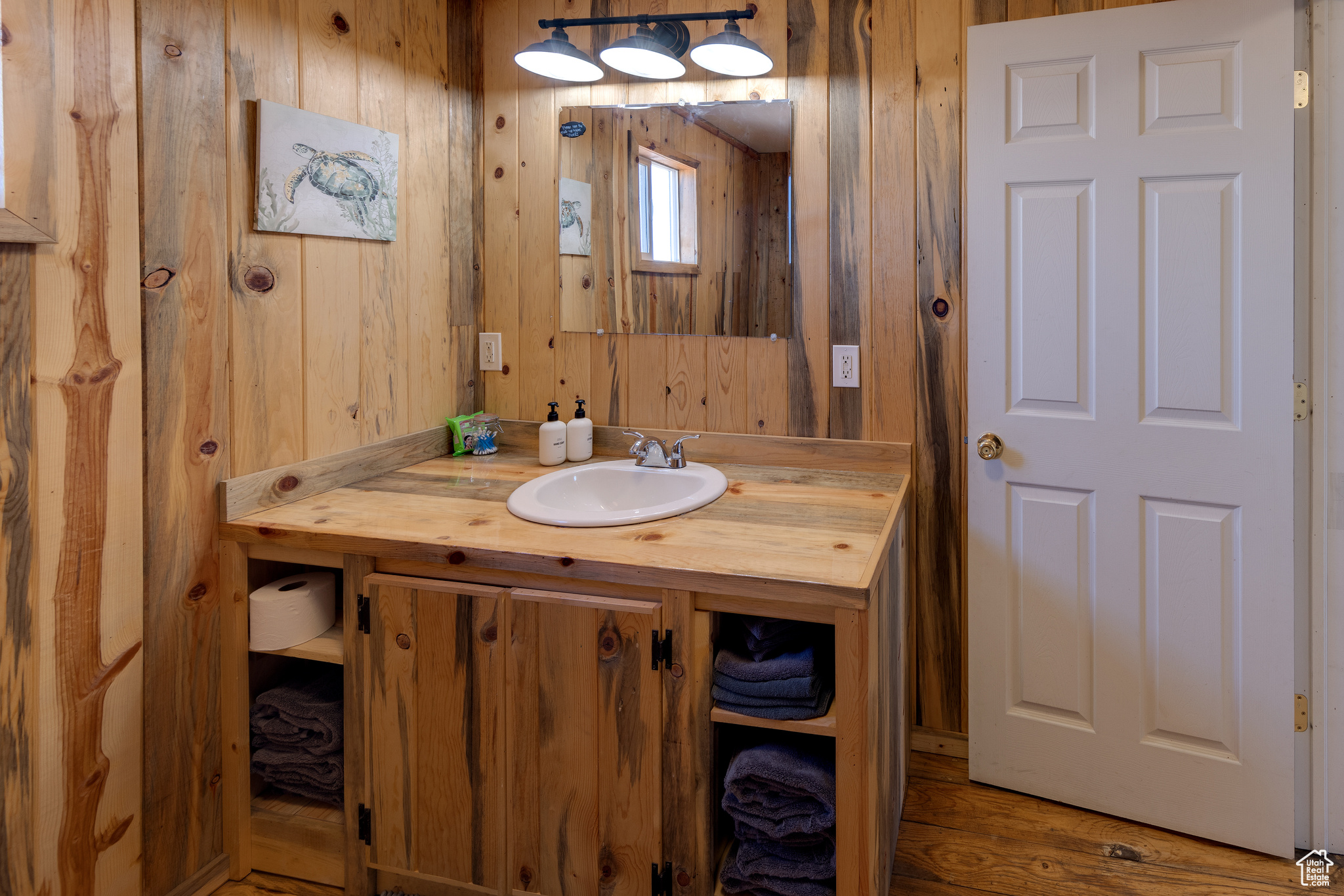 Bathroom featuring hardwood / wood-style flooring, vanity, and wood walls