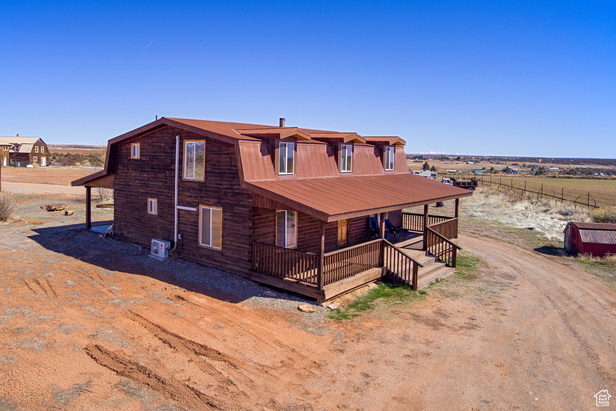 View of front of home featuring central AC unit, covered porch, and a rural view