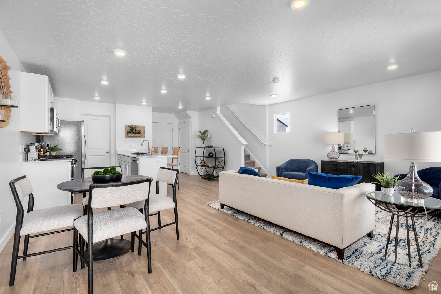 Living room featuring sink, a textured ceiling, and light wood-type flooring