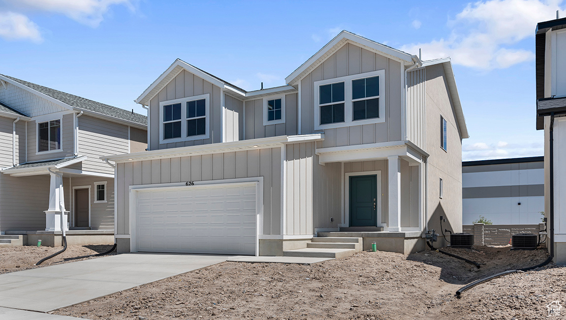 View of front facade with a garage and central AC