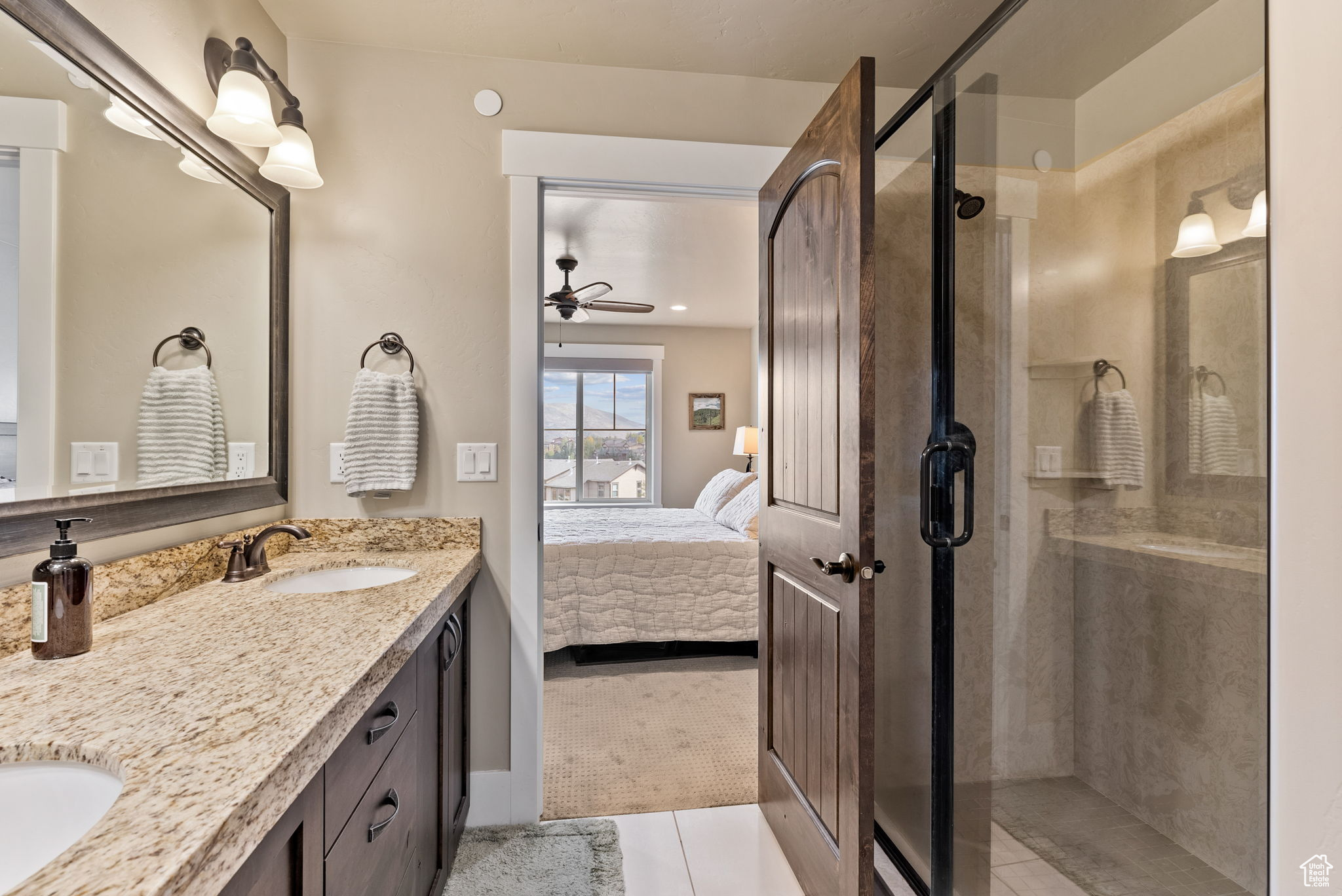 Bathroom with tile patterned floors, ceiling fan, an enclosed shower, and vanity