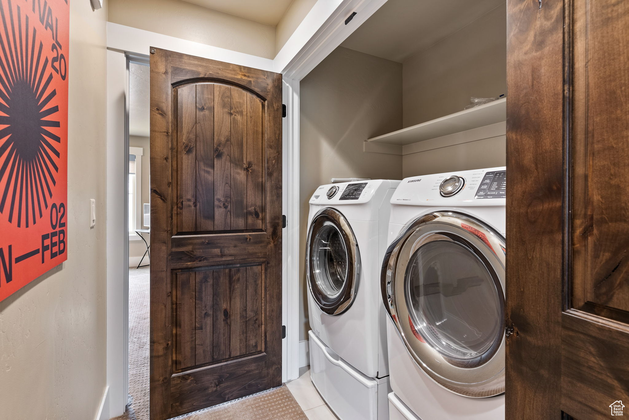 Clothes washing area featuring washer and clothes dryer and light tile patterned floors