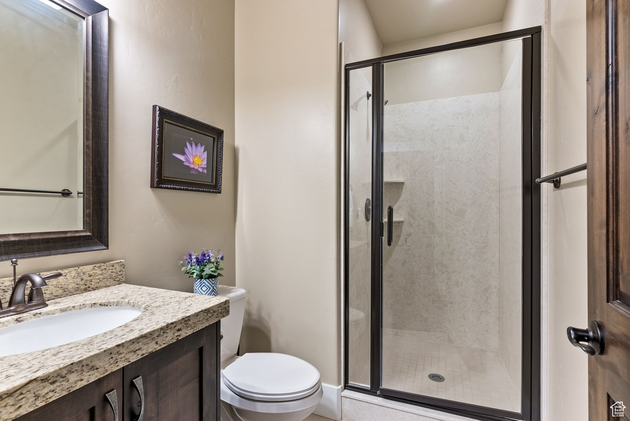 Bathroom with an enclosed shower, vanity, and toilet