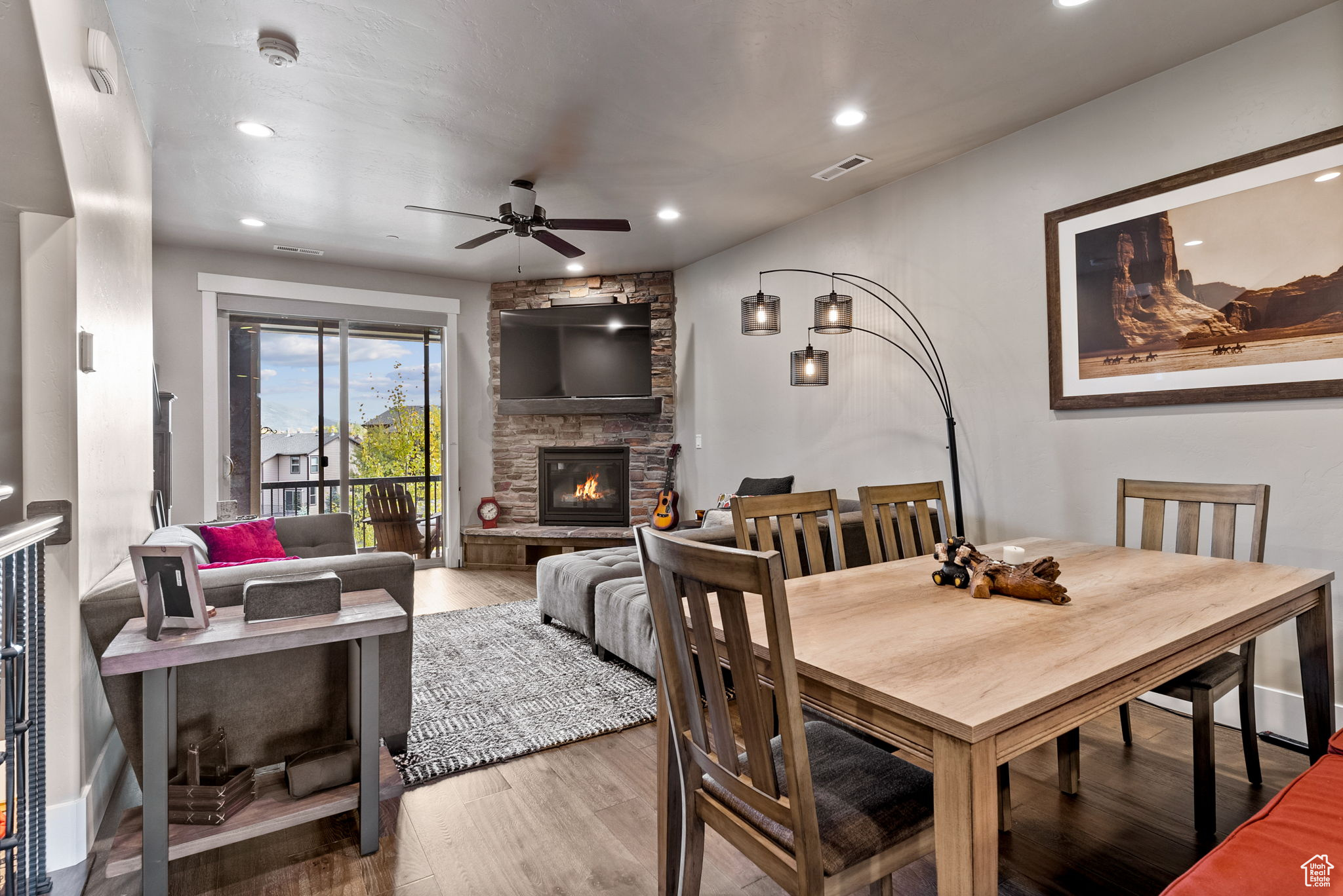 Dining space featuring a fireplace, hardwood / wood-style flooring, and ceiling fan