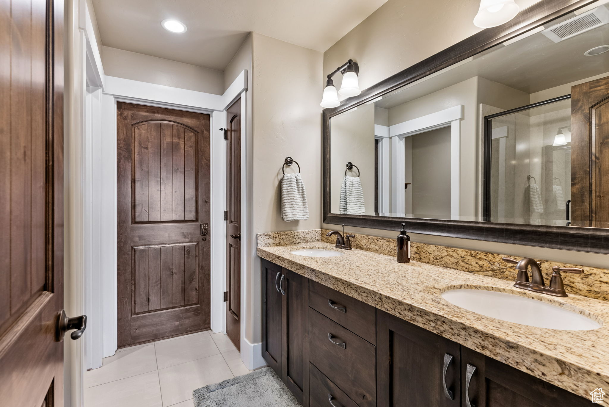 Bathroom featuring tile patterned floors, vanity, and walk in shower