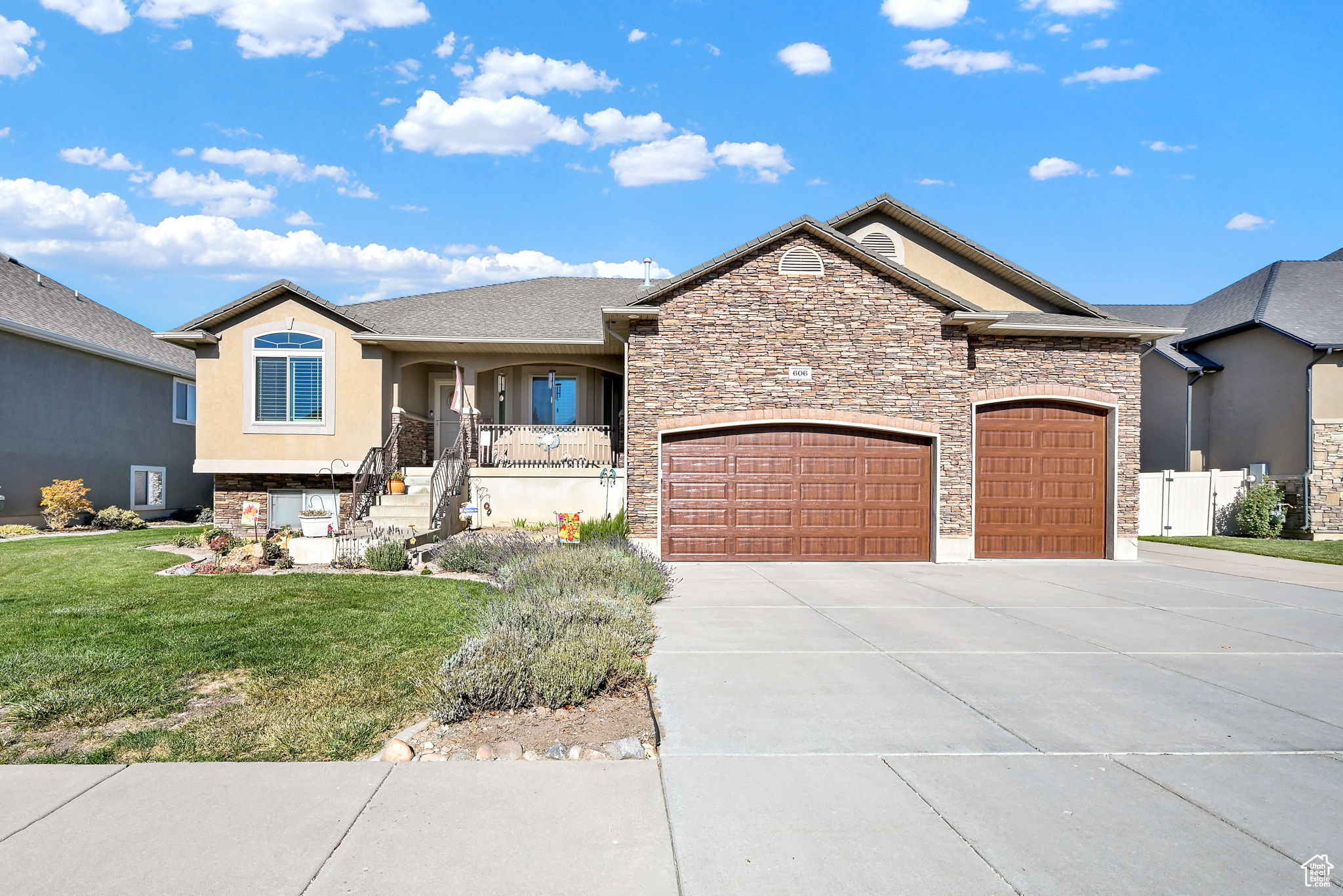 View of front of property with a garage and a front lawn