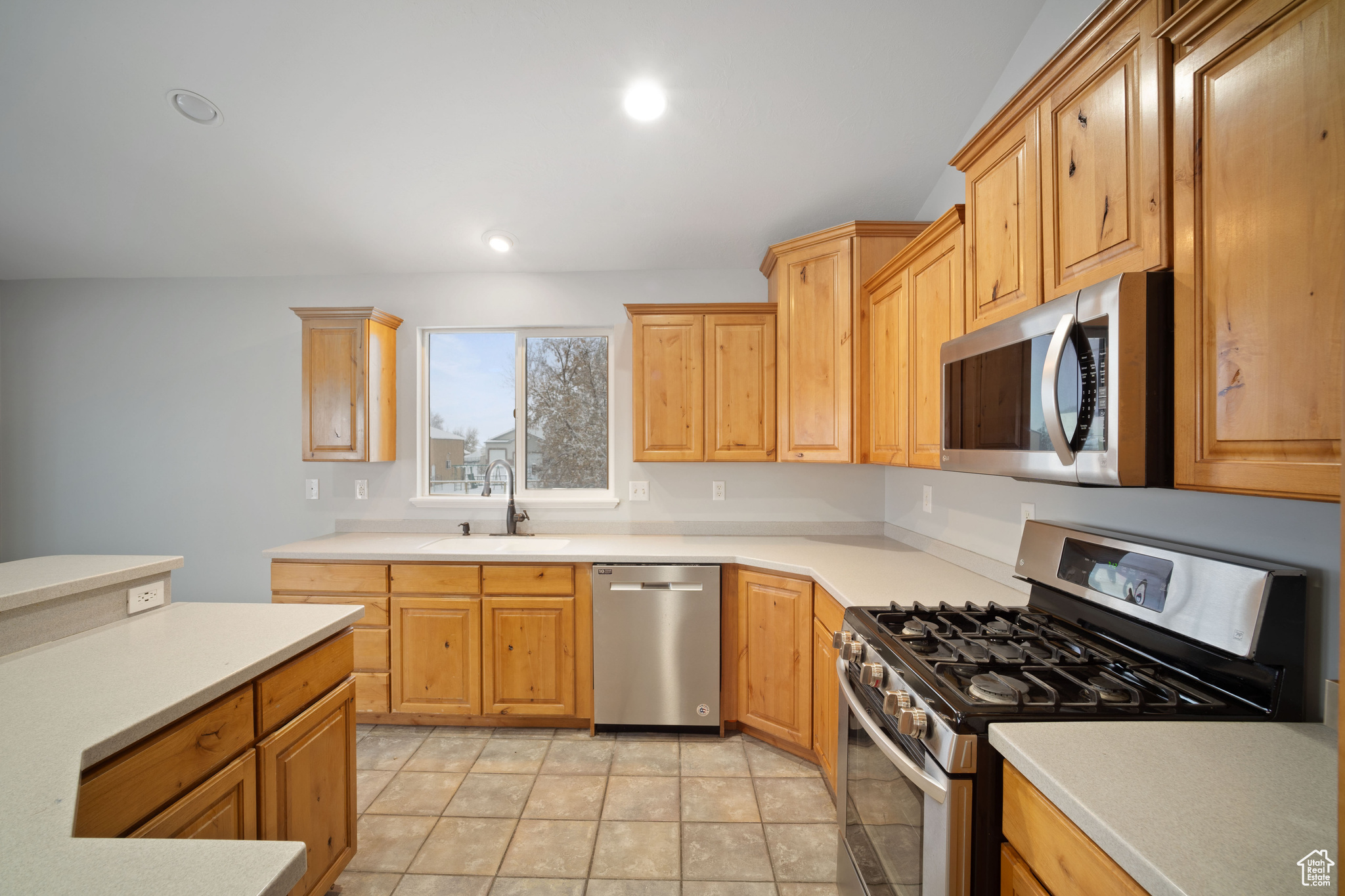 Kitchen with sink, light tile patterned floors, and stainless steel appliances