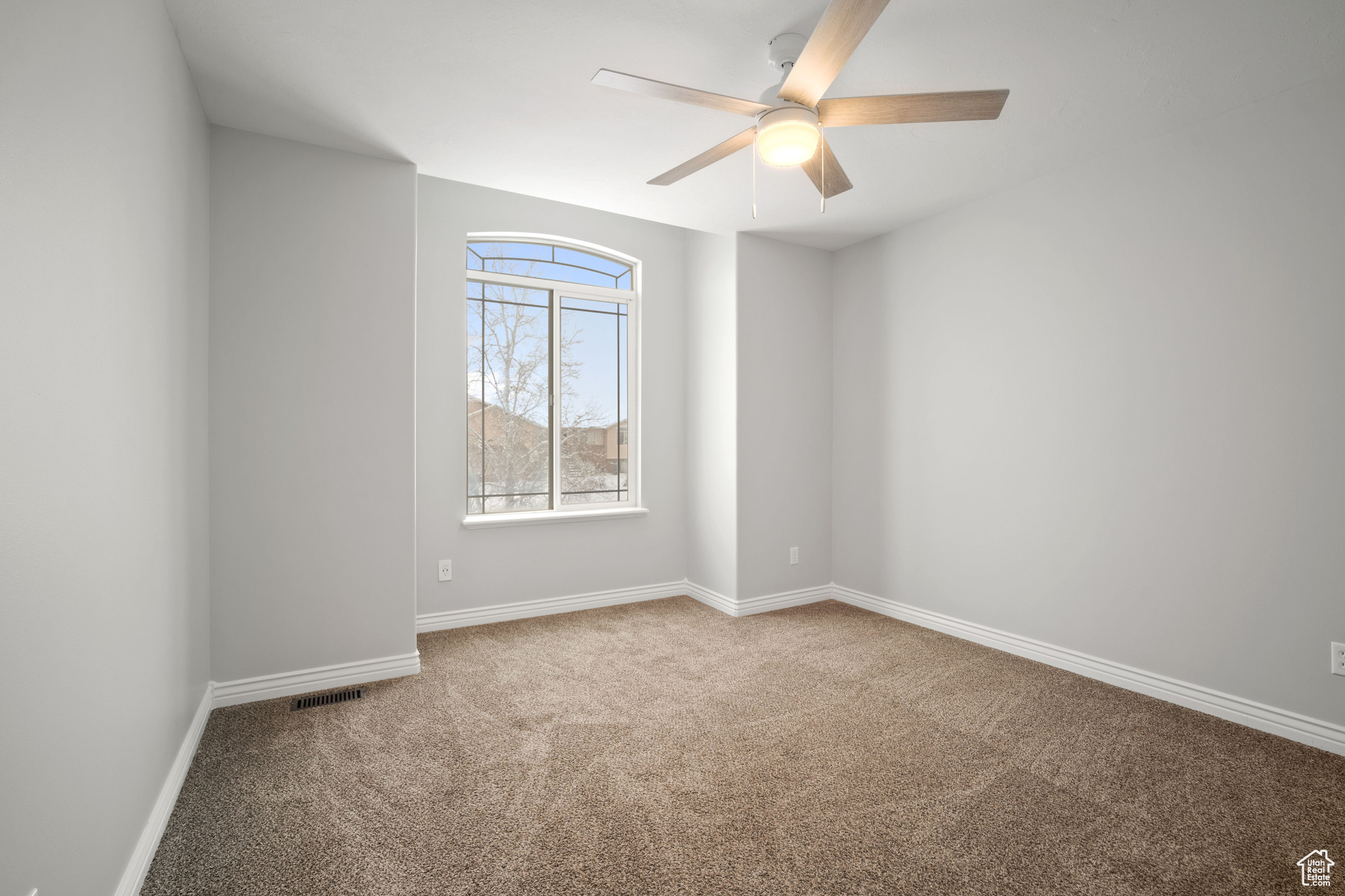 Empty room with carpet and ceiling fan