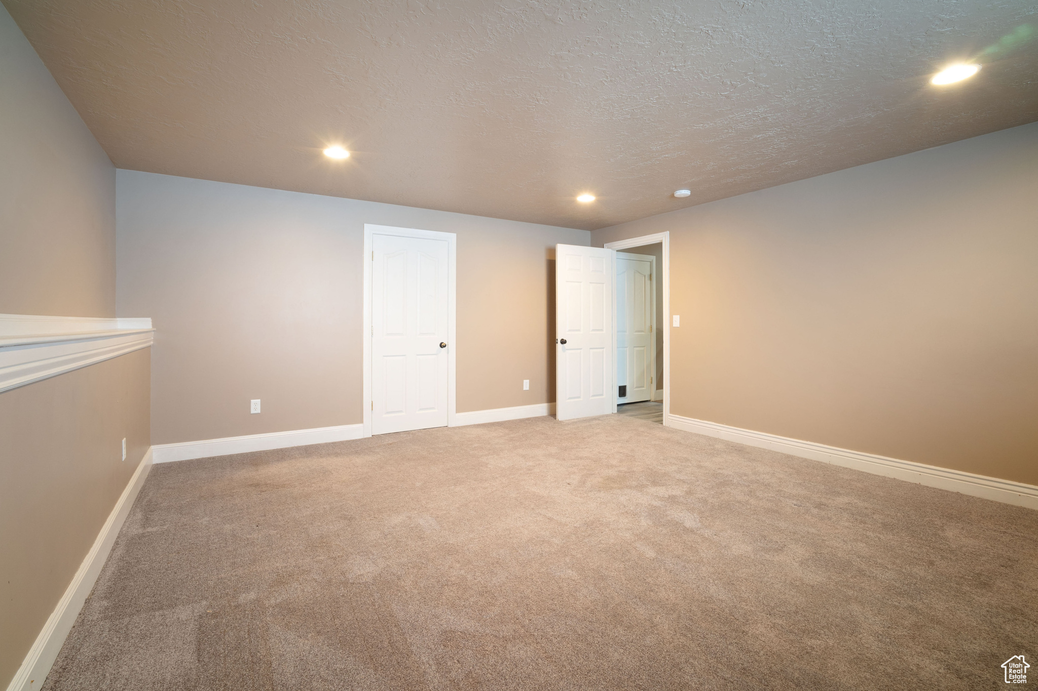 Carpeted spare room featuring a textured ceiling