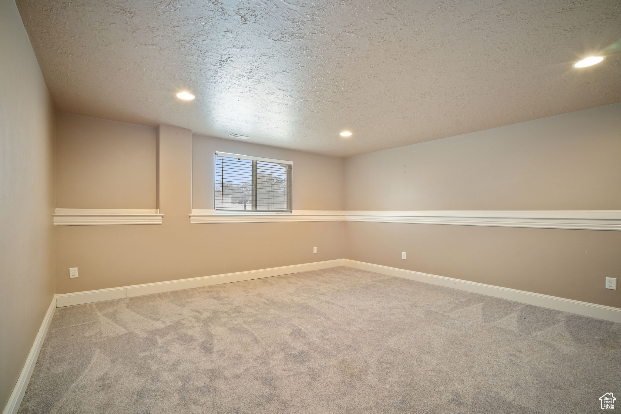 Spare room featuring carpet floors and a textured ceiling