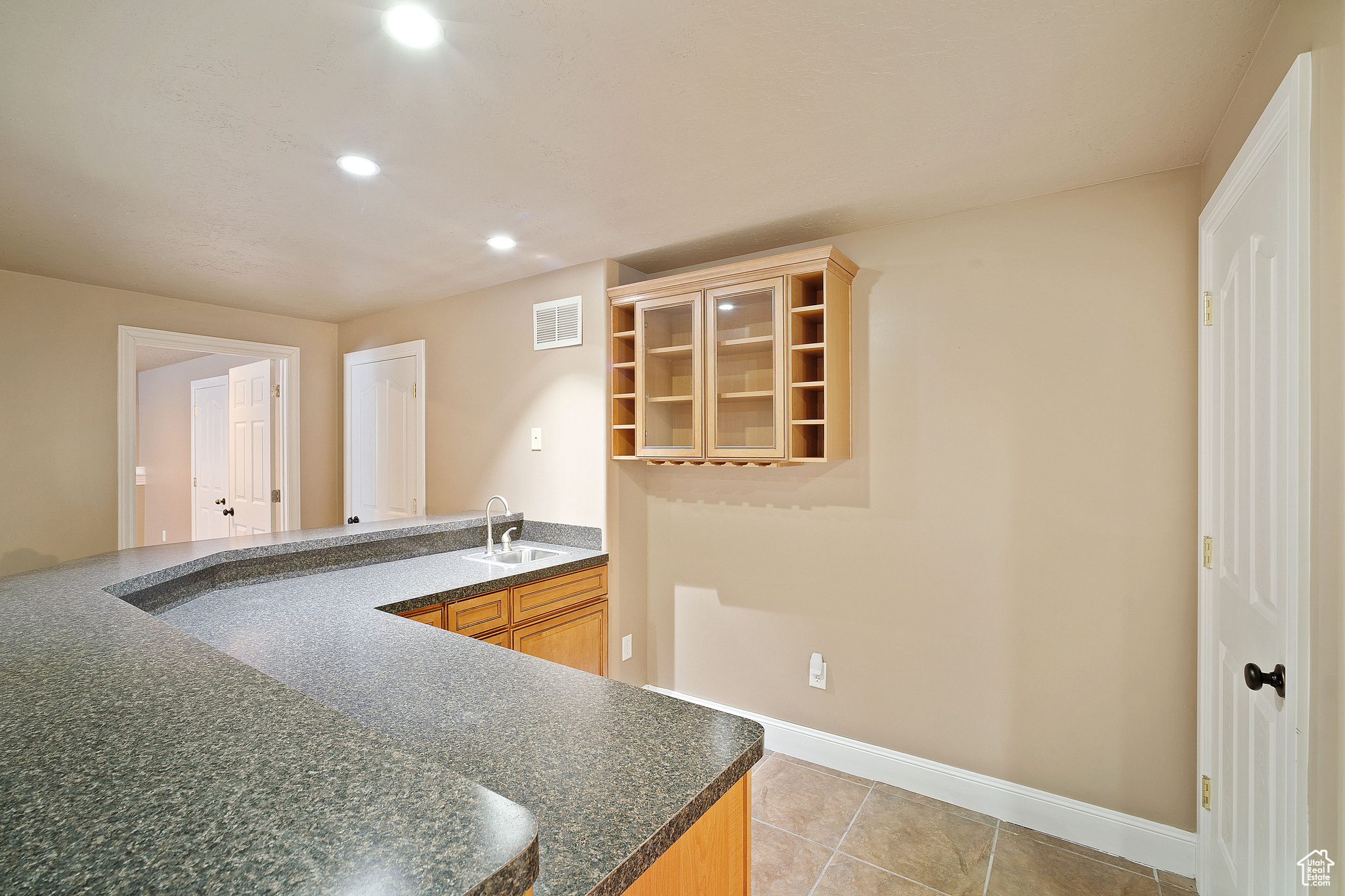 Kitchen featuring light brown cabinetry, sink, and light tile patterned floors