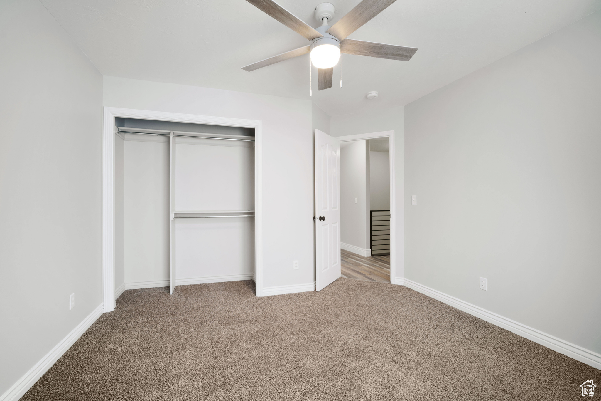 Unfurnished bedroom featuring ceiling fan, carpet floors, and a closet