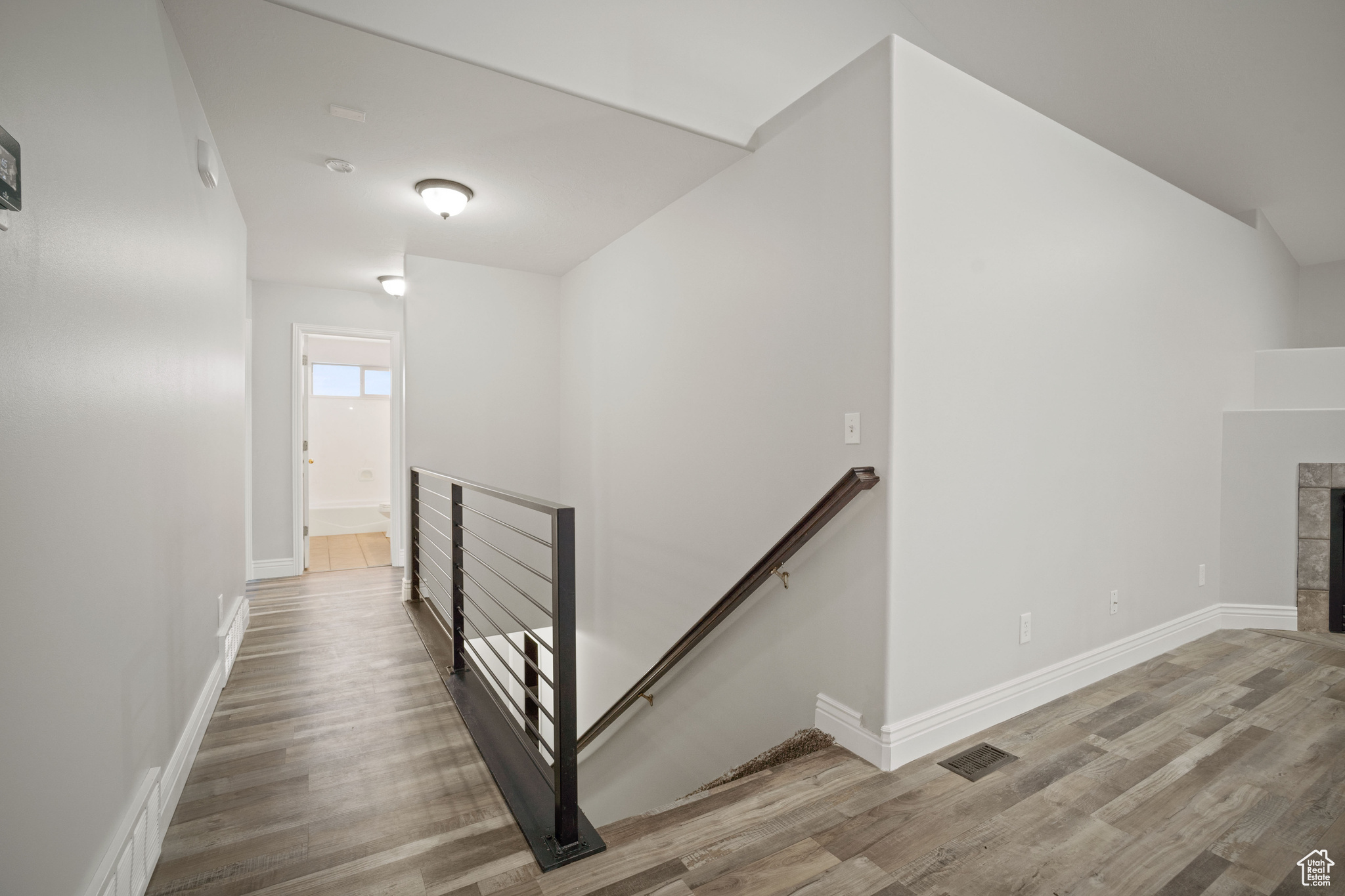 Stairs with a fireplace and hardwood / wood-style flooring