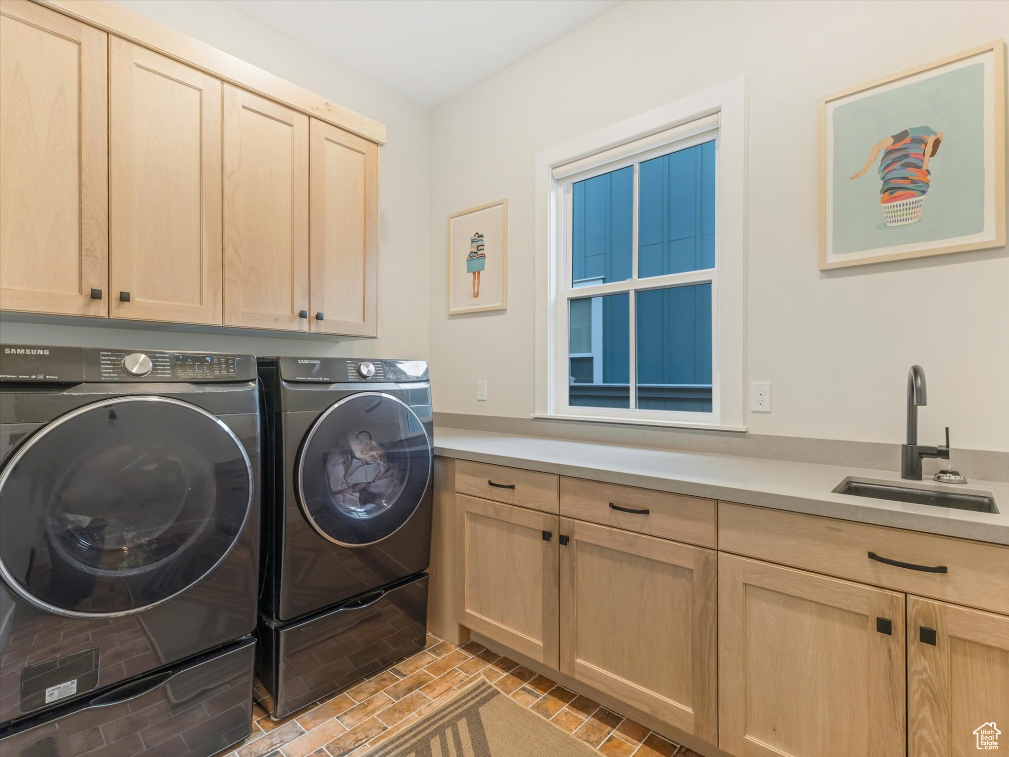 Clothes washing area with cabinets, independent washer and dryer, and sink