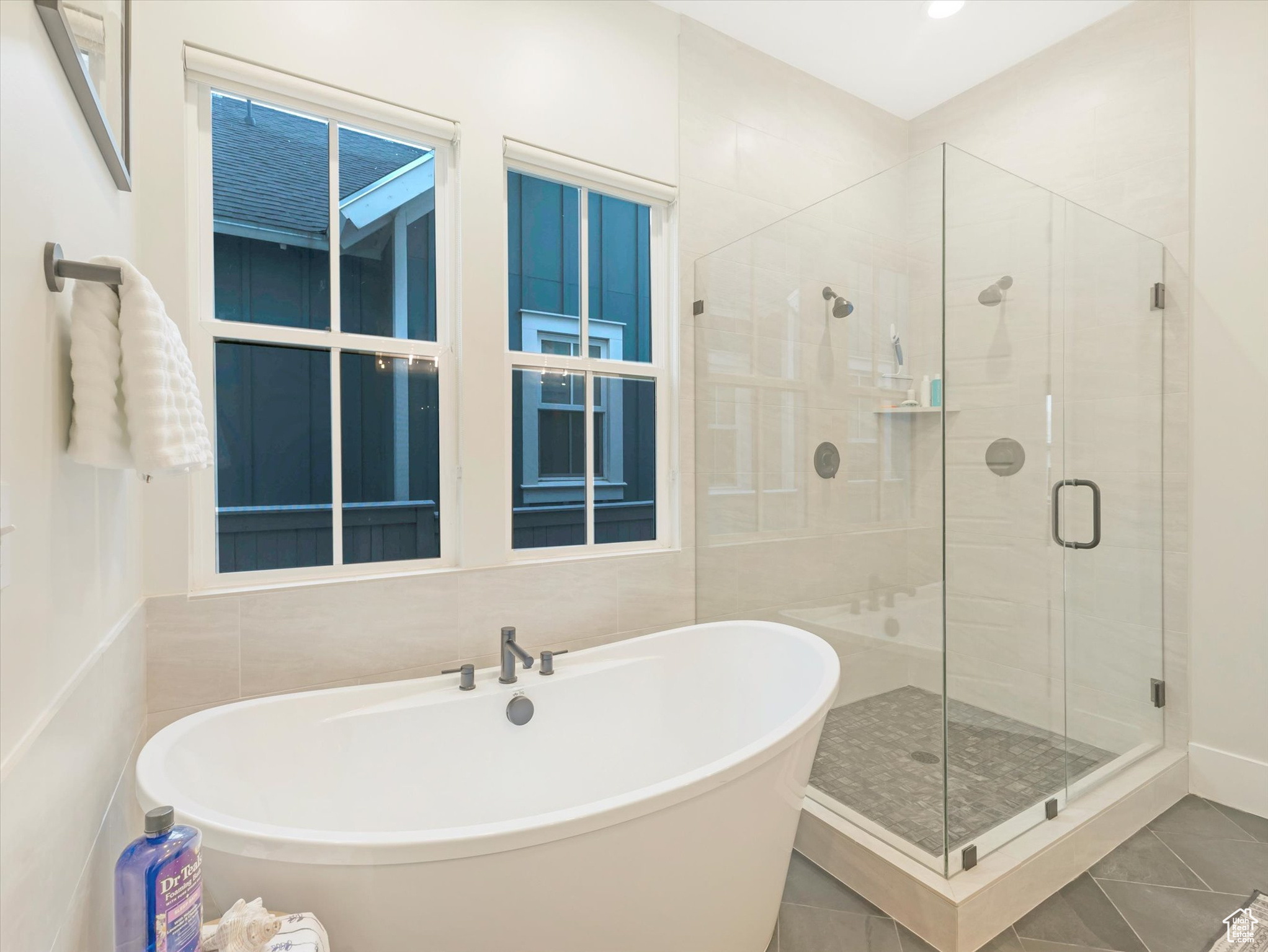 Bathroom with tile patterned floors, separate shower and tub, and tile walls