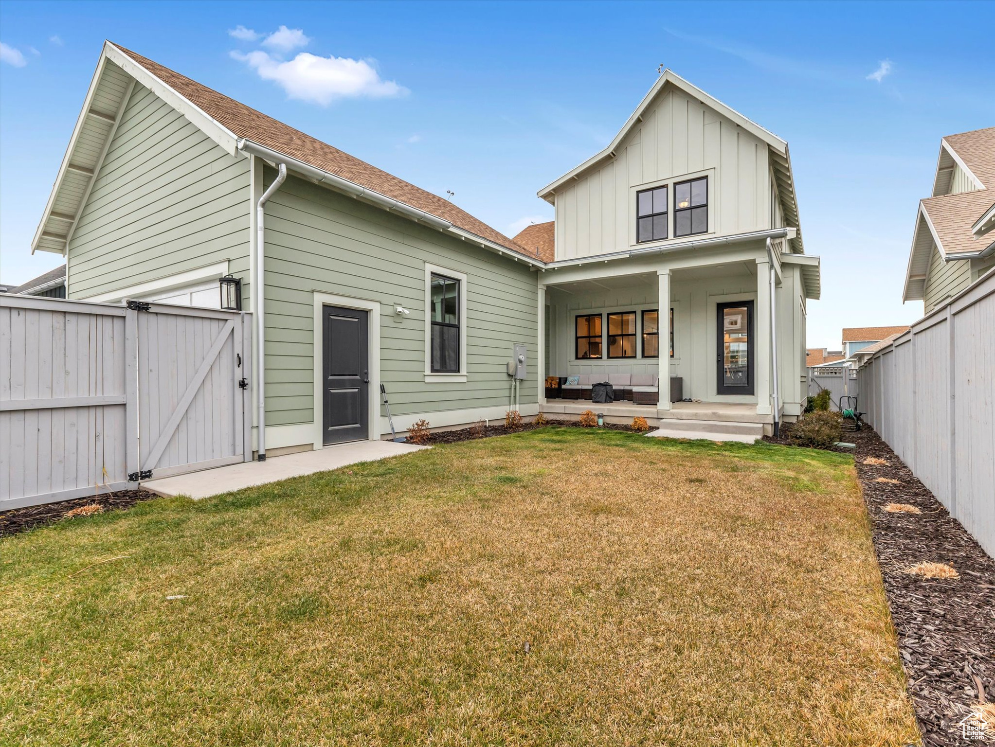 Back of property featuring a porch and a yard