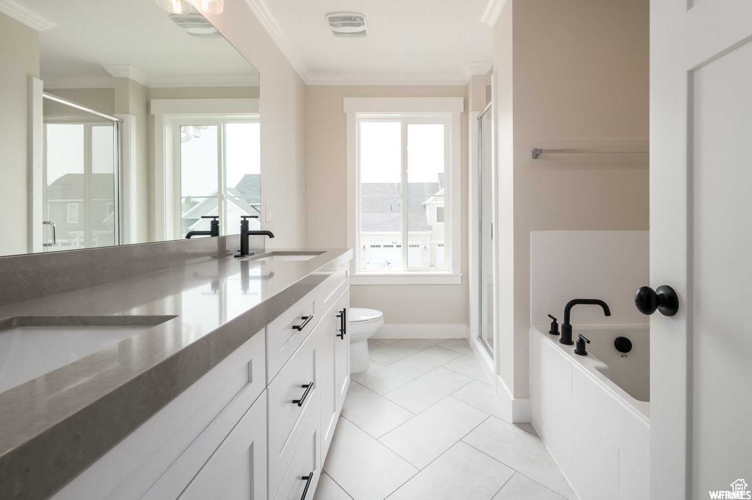 Full bathroom with vanity, crown molding, tile patterned flooring, toilet, and independent shower and bath