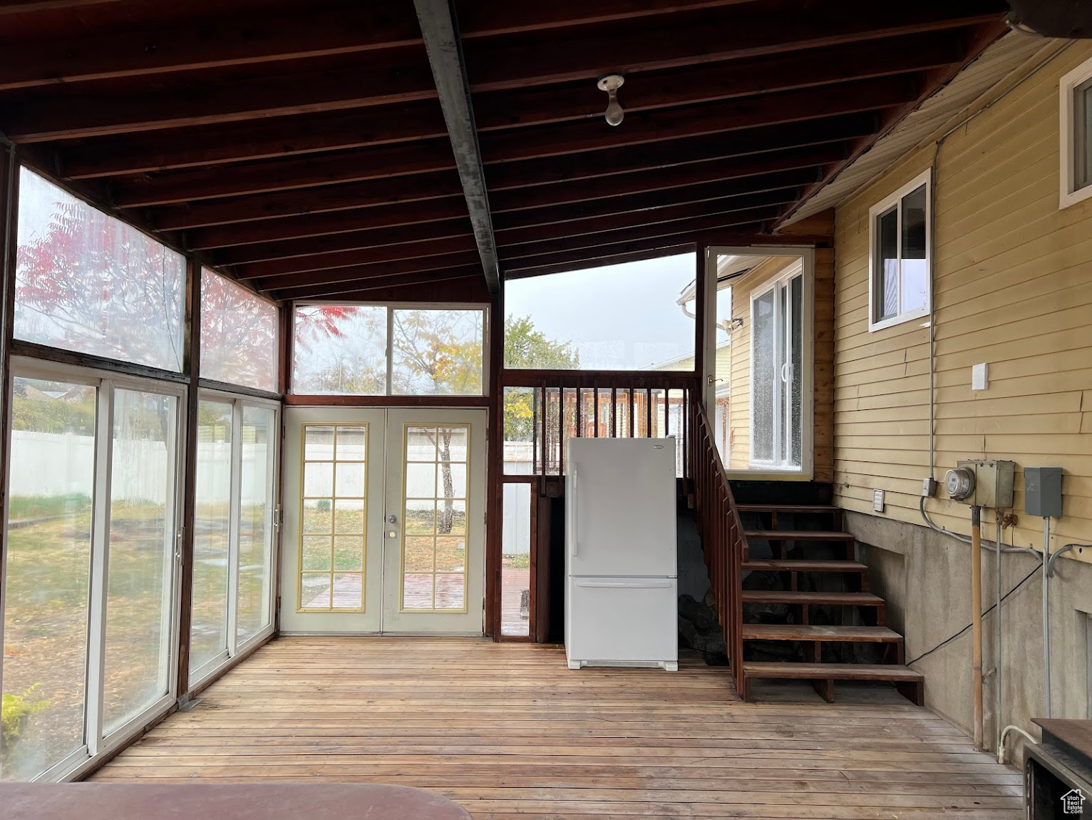 Unfurnished sunroom with lofted ceiling with beams and french doors