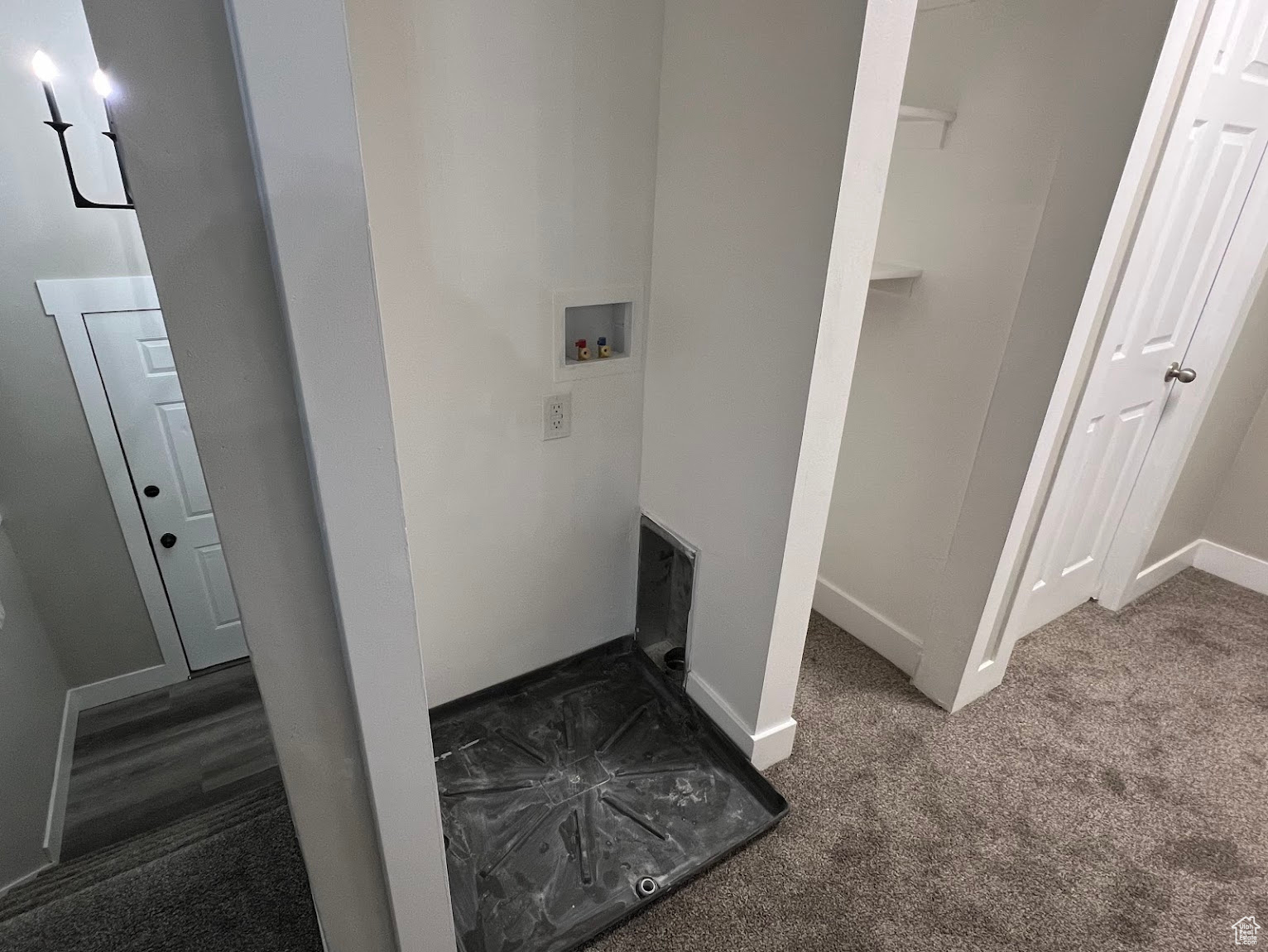 Laundry area with dark colored carpet and hookup for a washing machine