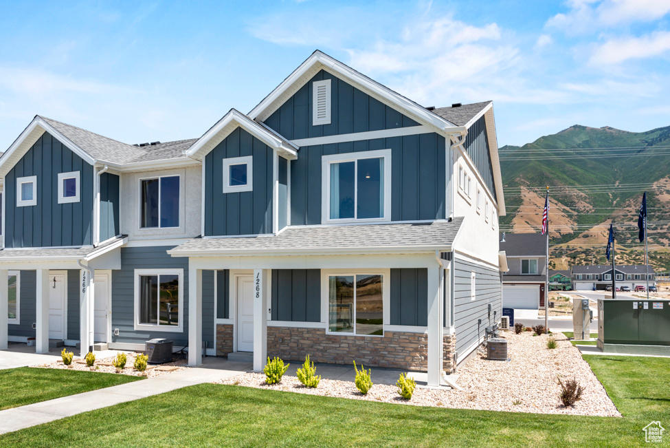 View of front of home with a mountain view and a front lawn