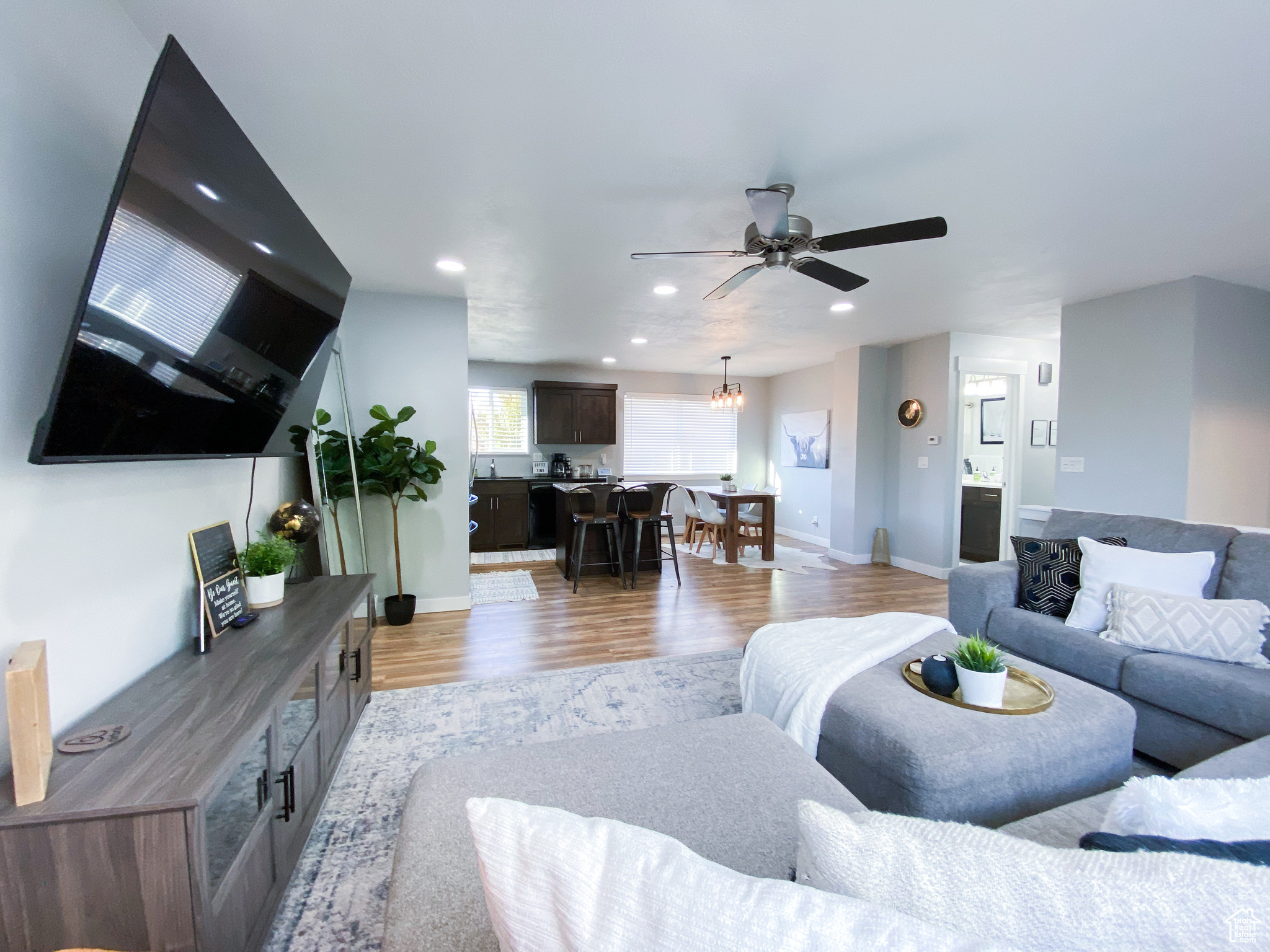 Upstairs Living room with ceiling fan with notable chandelier and light hardwood / wood-style floors