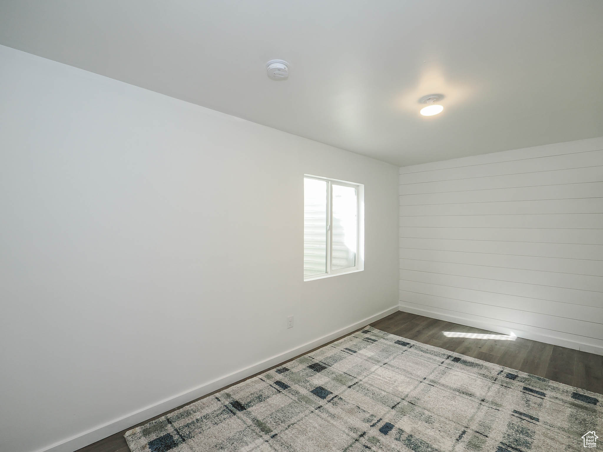 Empty room with dark hardwood / wood-style flooring