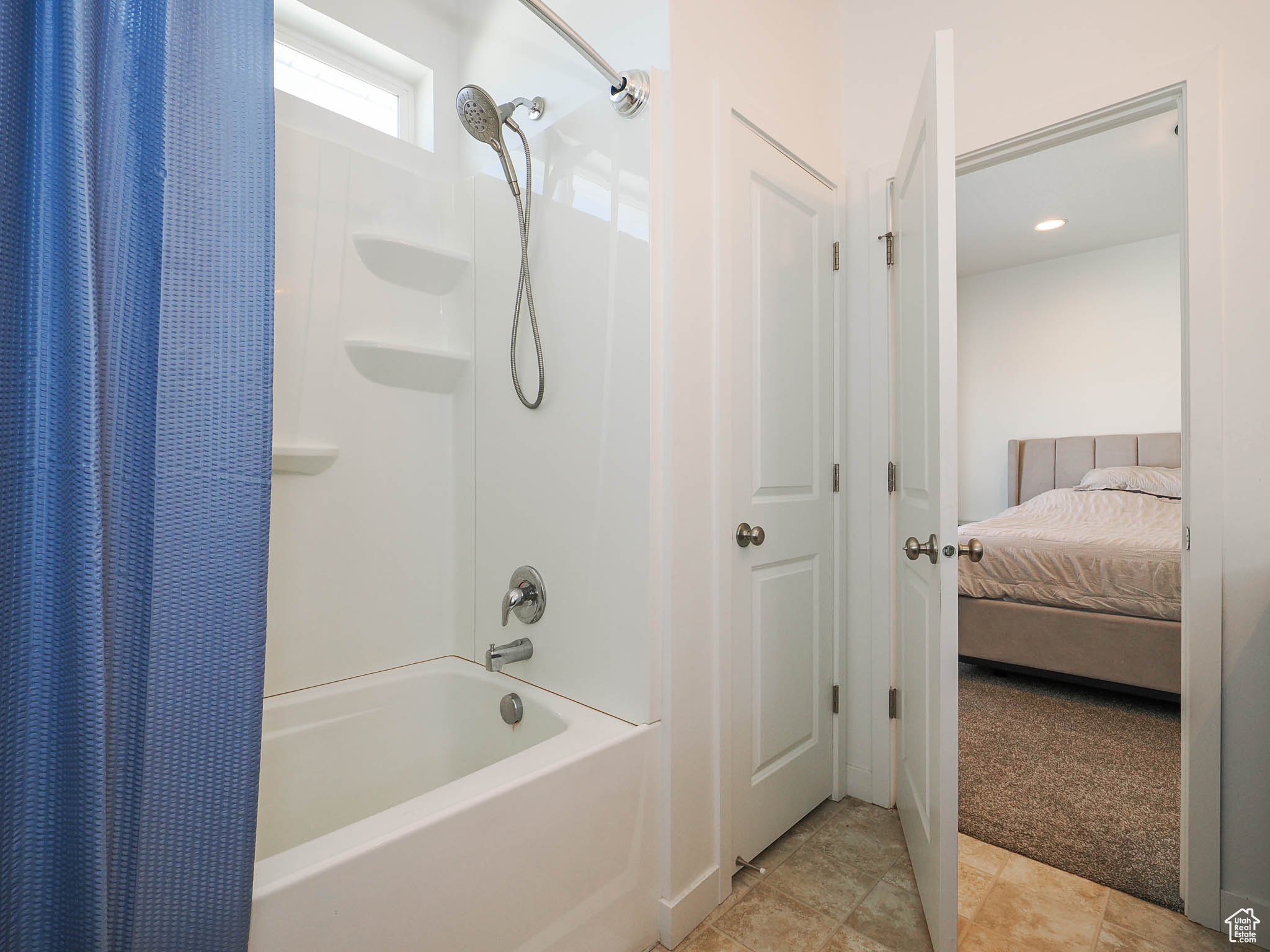 Bathroom featuring tile patterned flooring and shower / tub combo with curtain