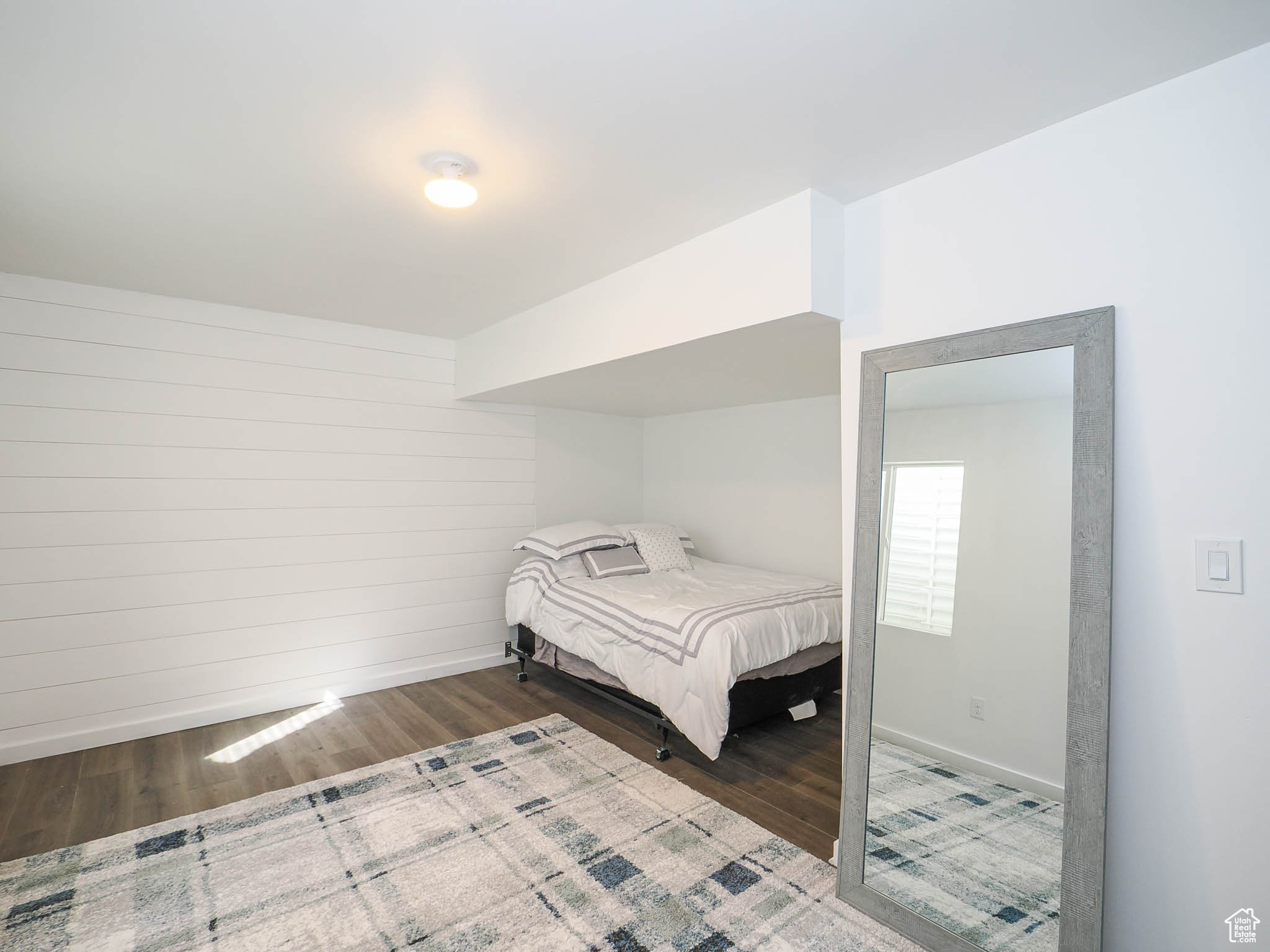 Bedroom featuring wood-type flooring and wood walls