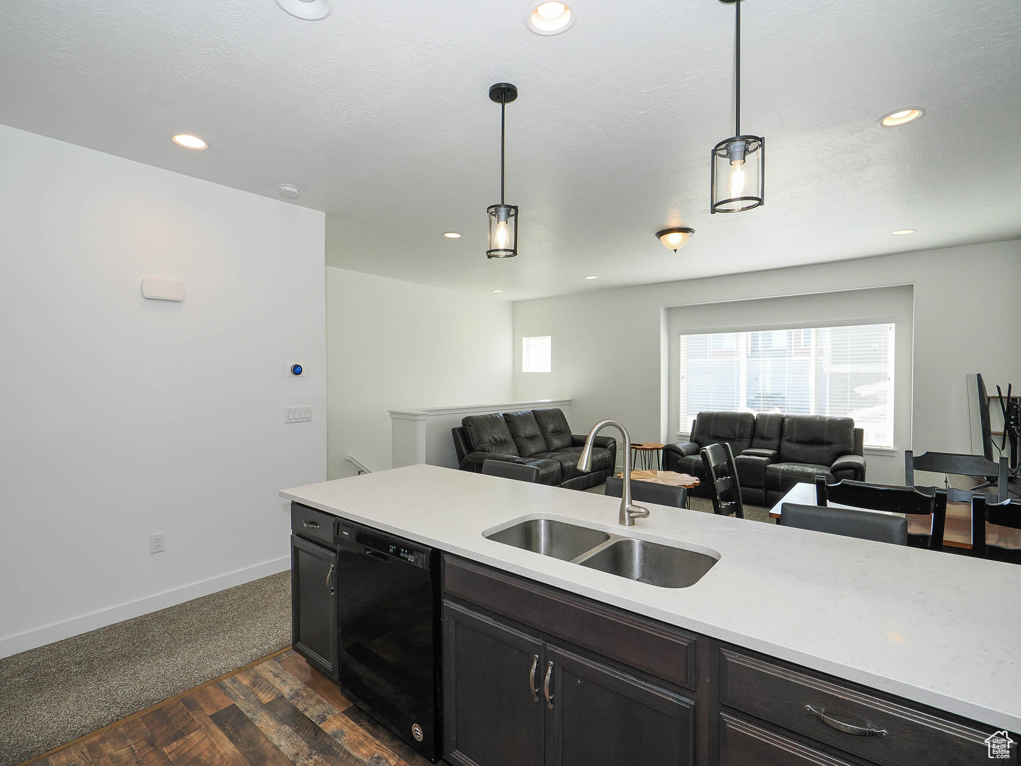 Kitchen featuring dishwasher, dark hardwood / wood-style floors, sink, and hanging light fixtures