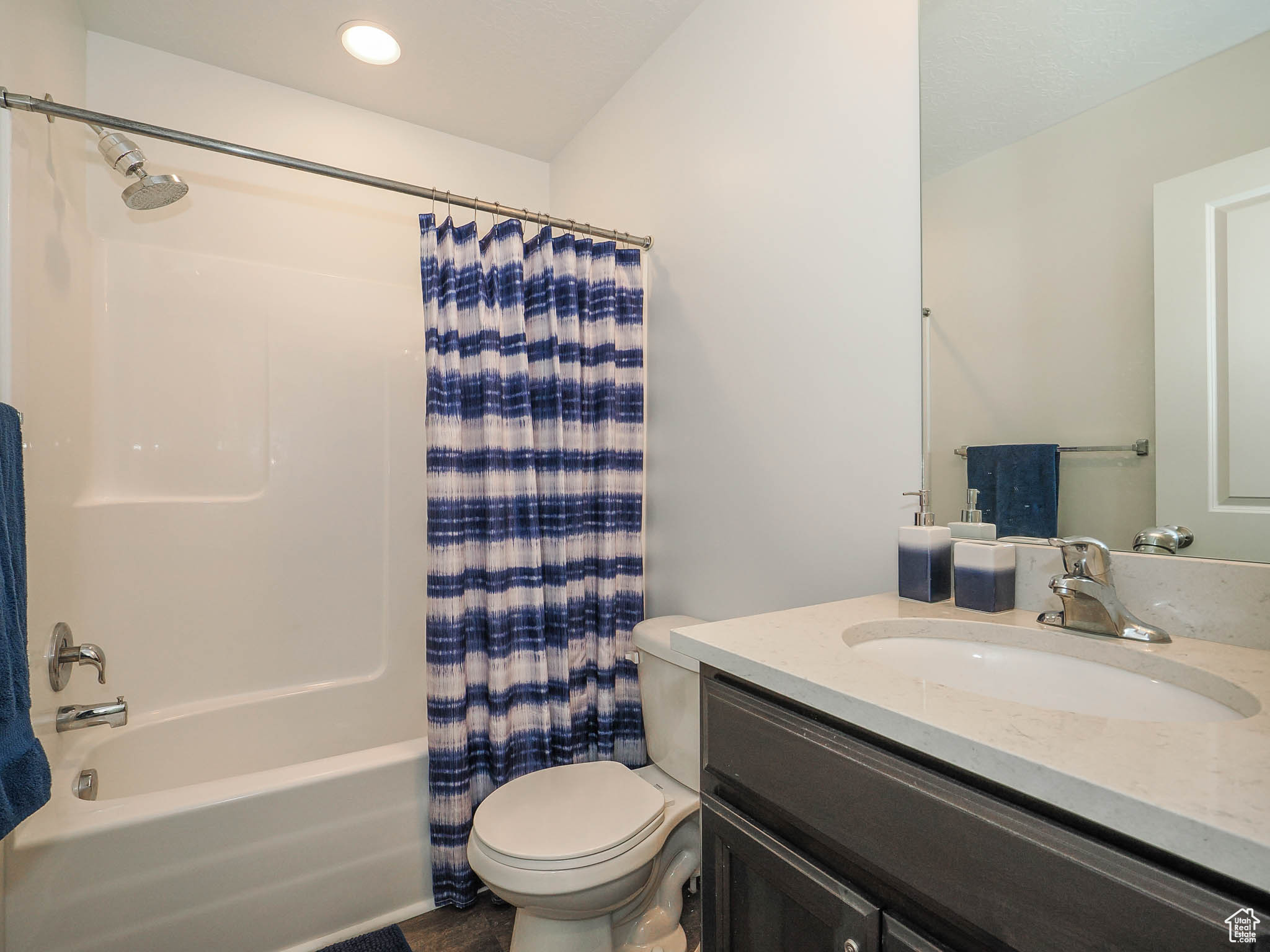 Full bathroom featuring shower / tub combo, vanity, and toilet