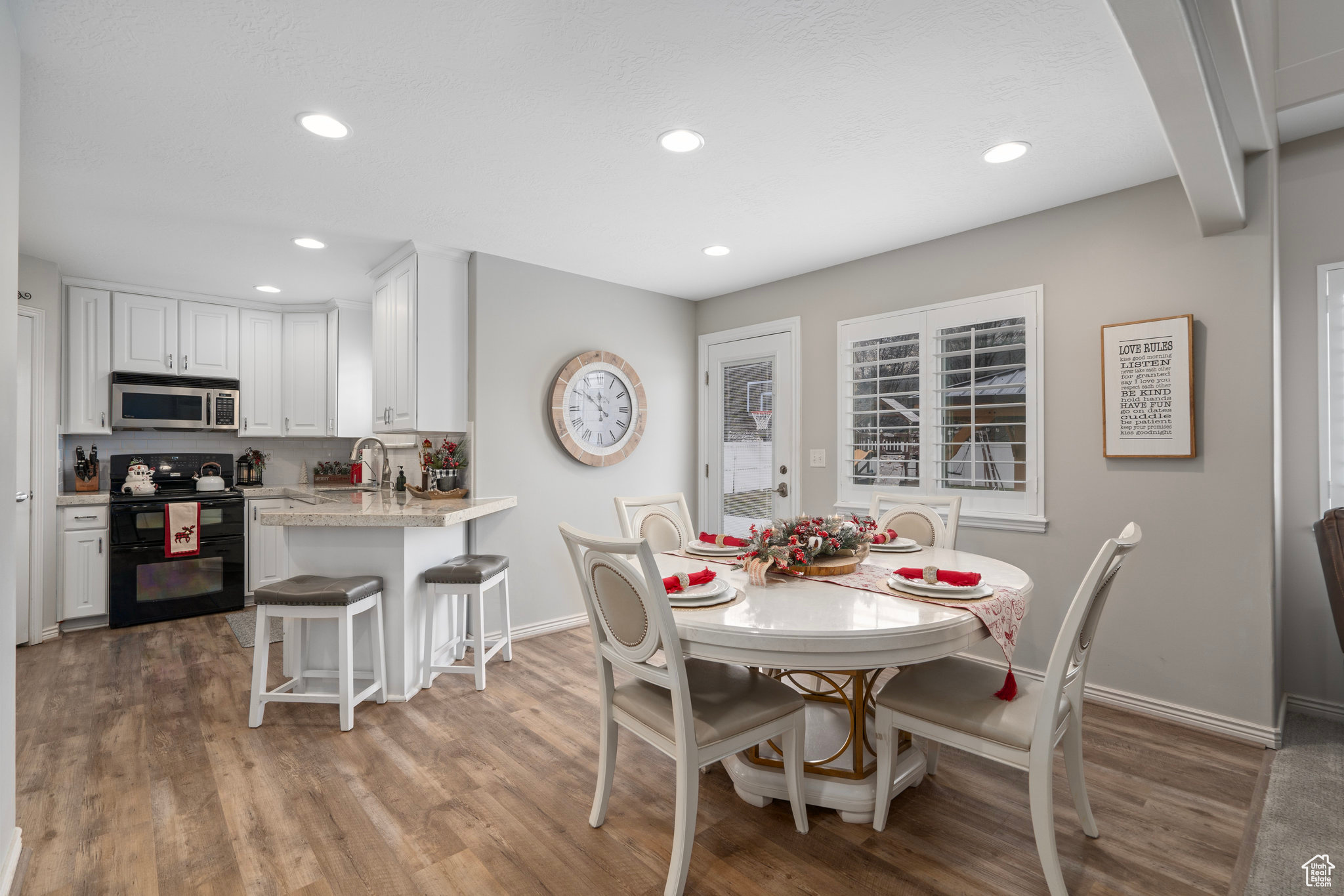 Dining area with beam ceiling, dark wood-type flooring, and sink