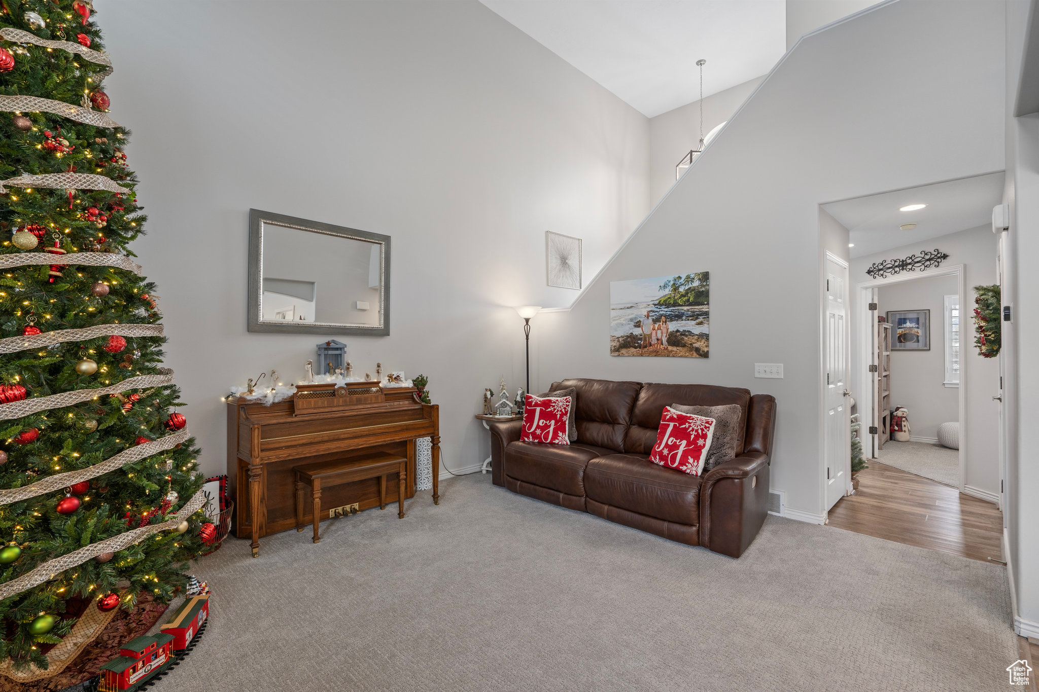 Living room featuring light carpet and a high ceiling