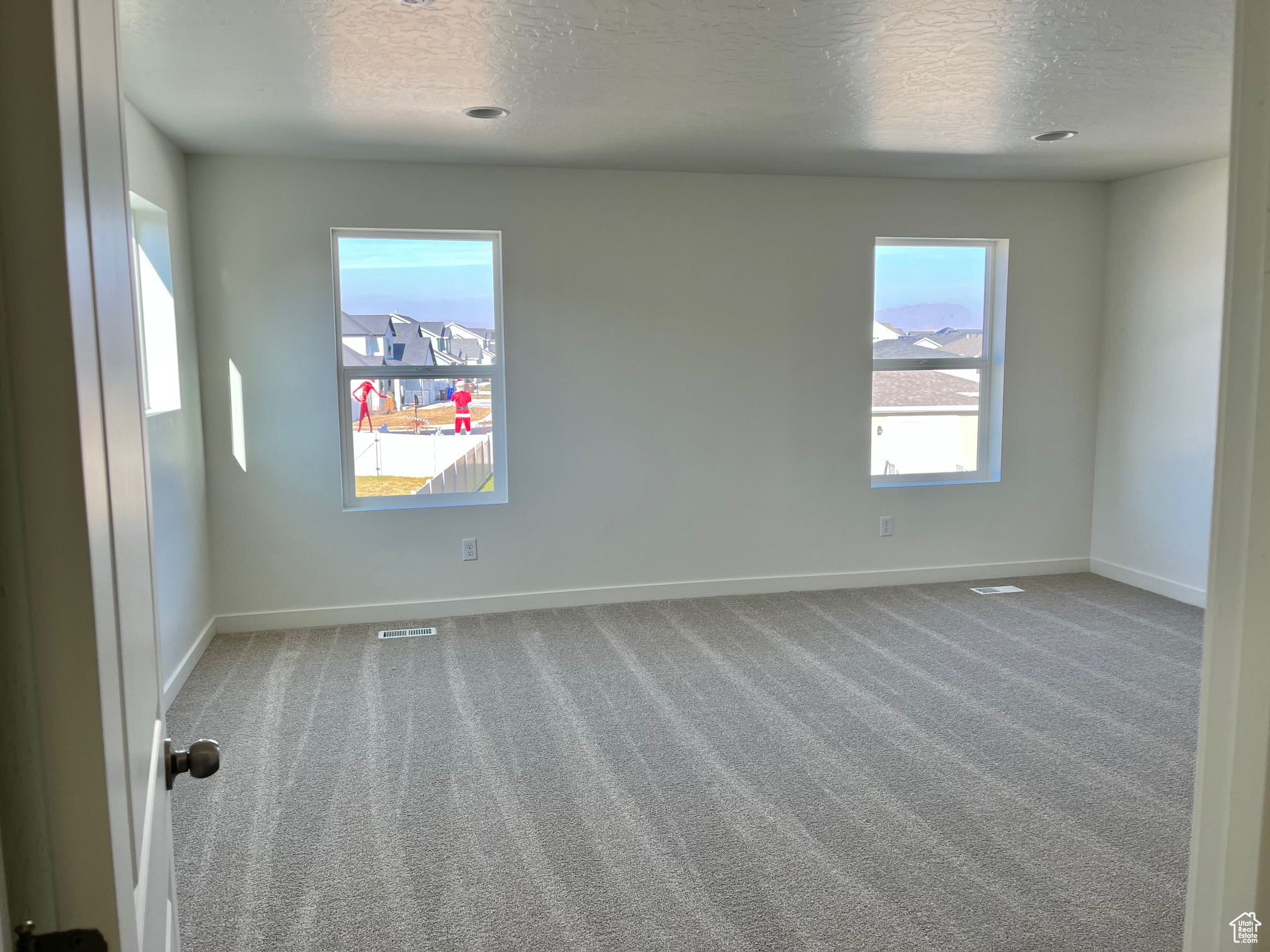 Spare room featuring carpet flooring and a textured ceiling