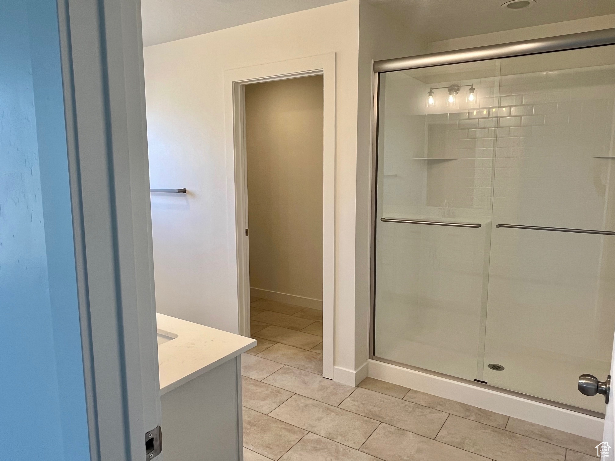 Bathroom with tile patterned floors, vanity, and a shower with shower door