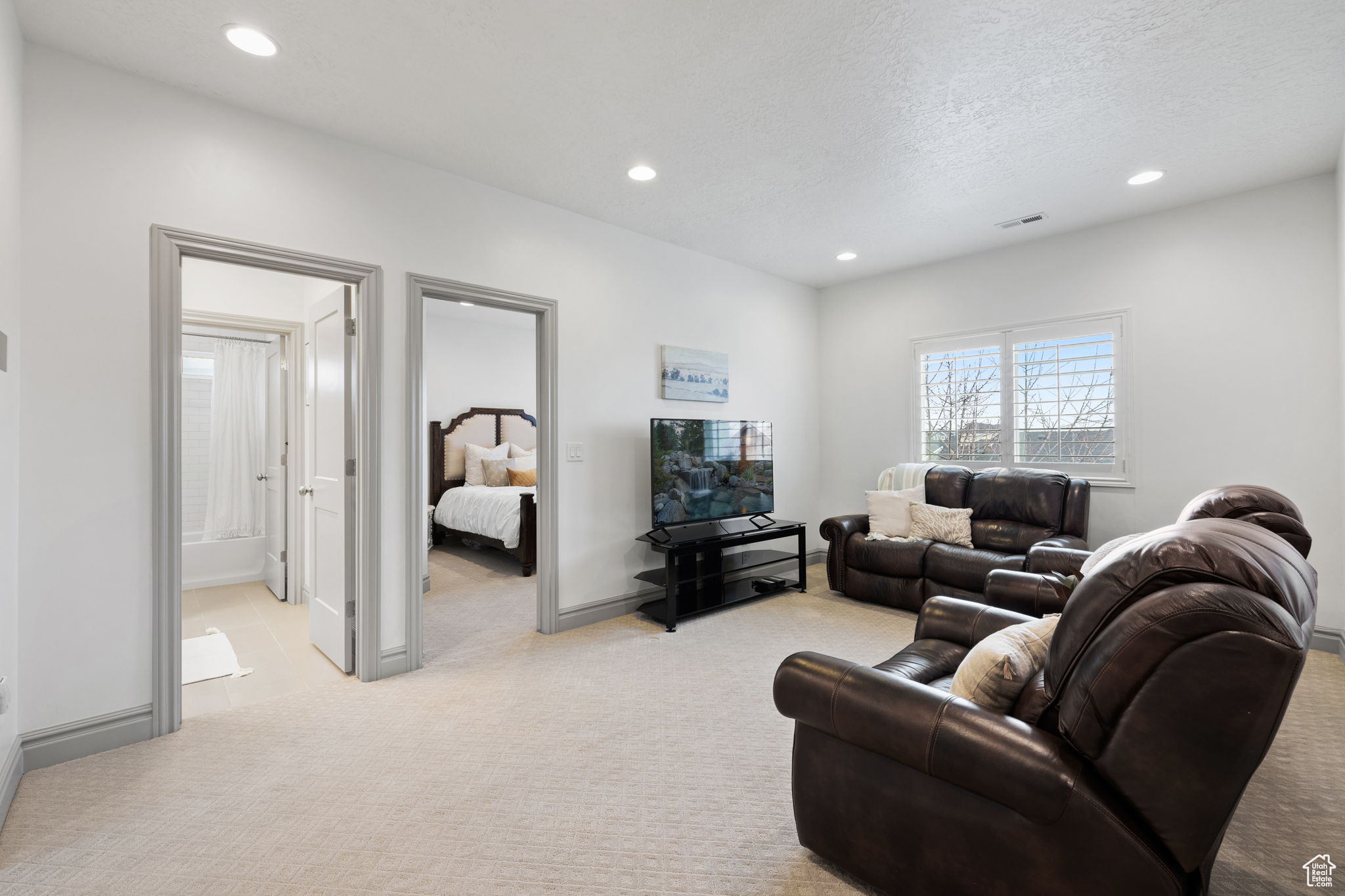 Carpeted living room with a textured ceiling