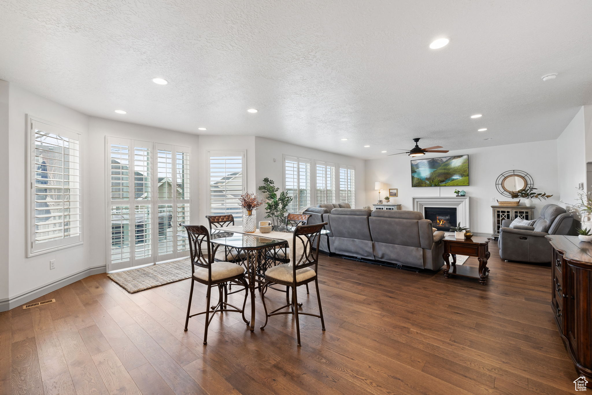 Dining space featuring dark hardwood / wood-style floors, ceiling fan, and a textured ceiling