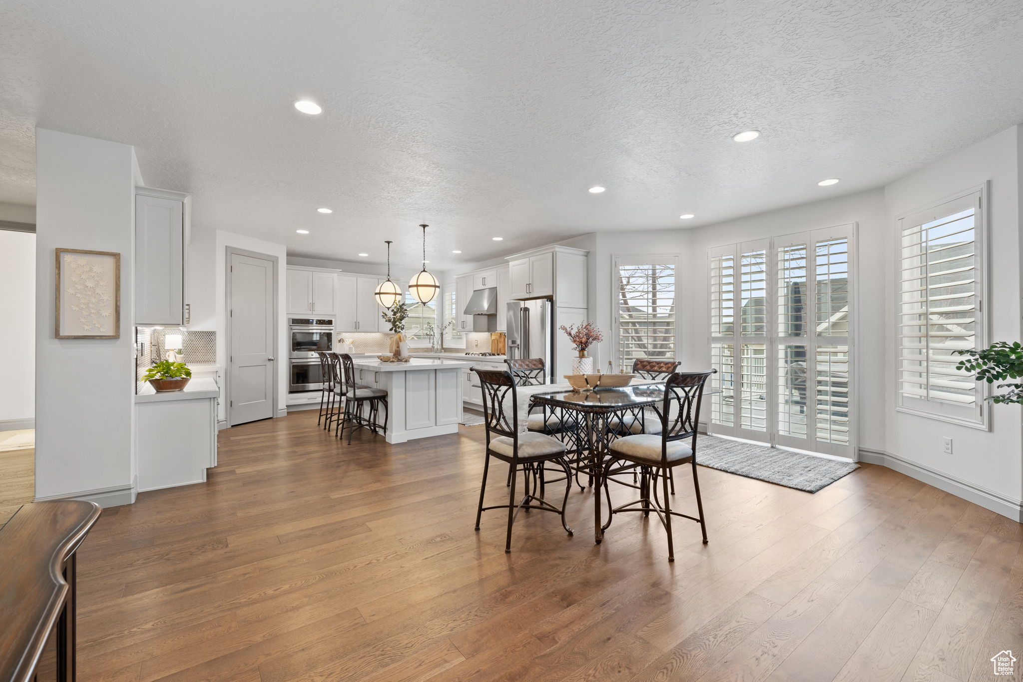 Dining area featuring wood-type flooring and a textured ceiling