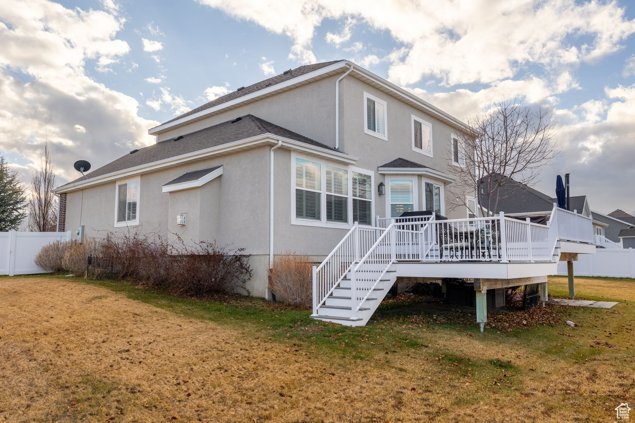 Back of property with a yard and a deck