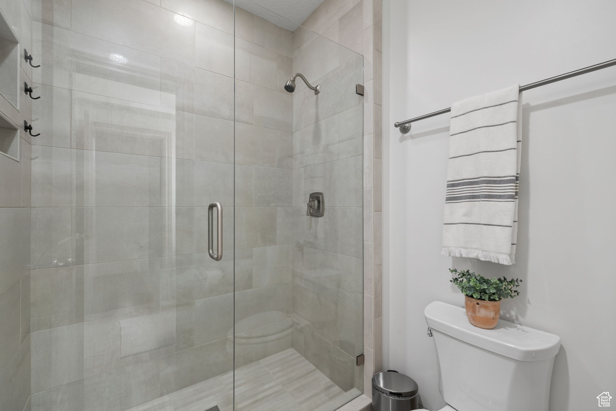 Bathroom featuring toilet and a shower with shower door