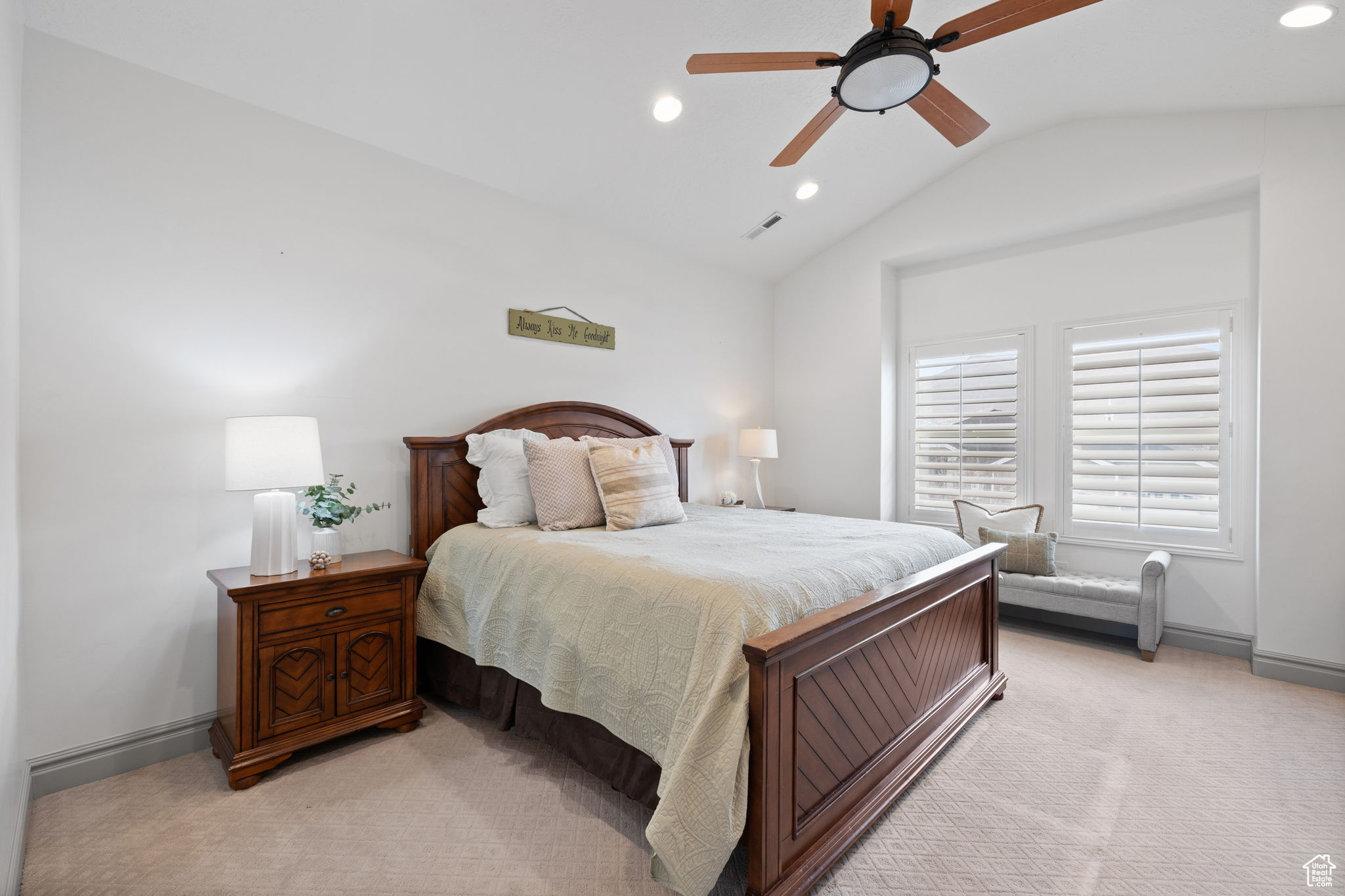 Carpeted bedroom featuring ceiling fan and lofted ceiling